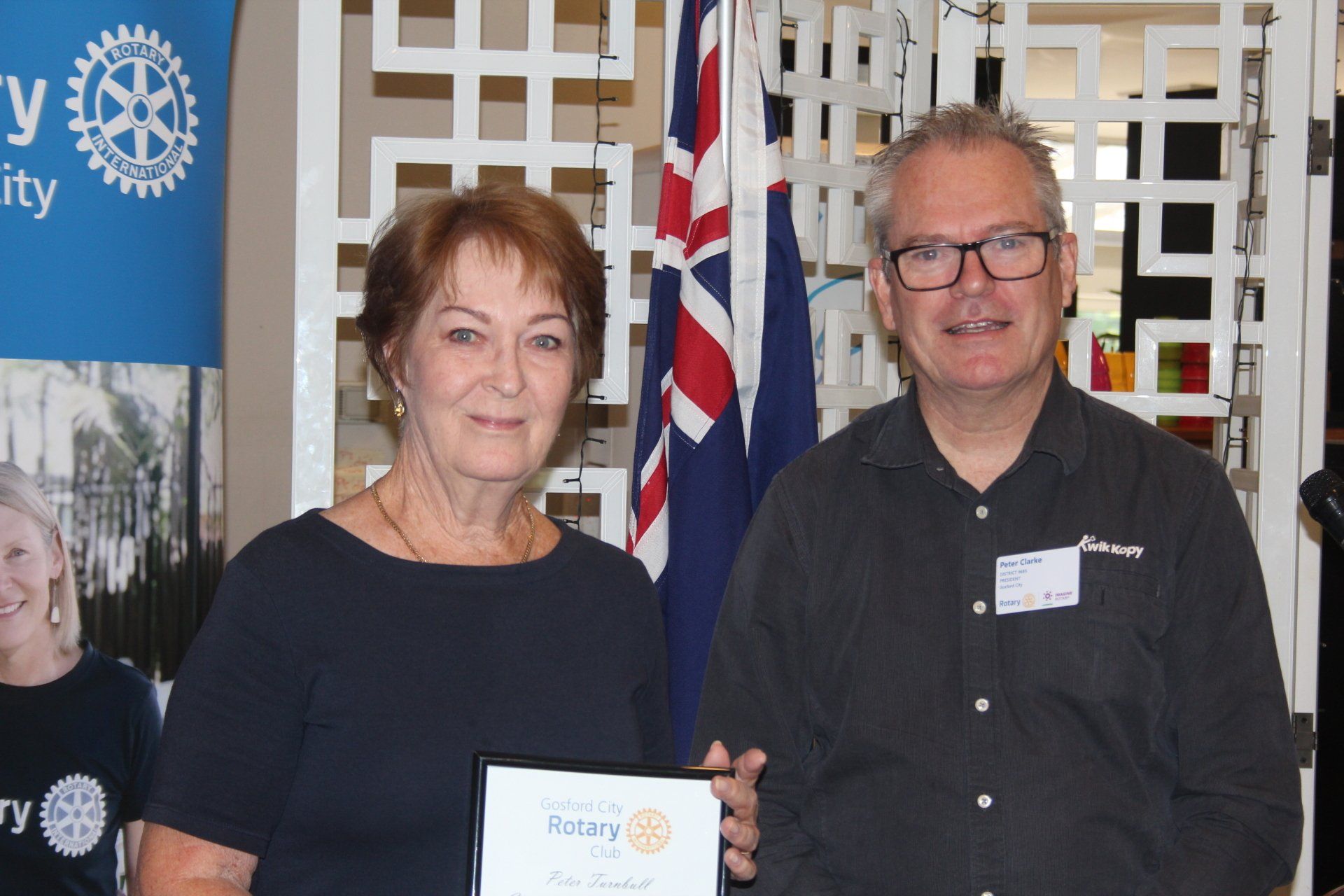 A man and a woman are standing next to each other holding a certificate.