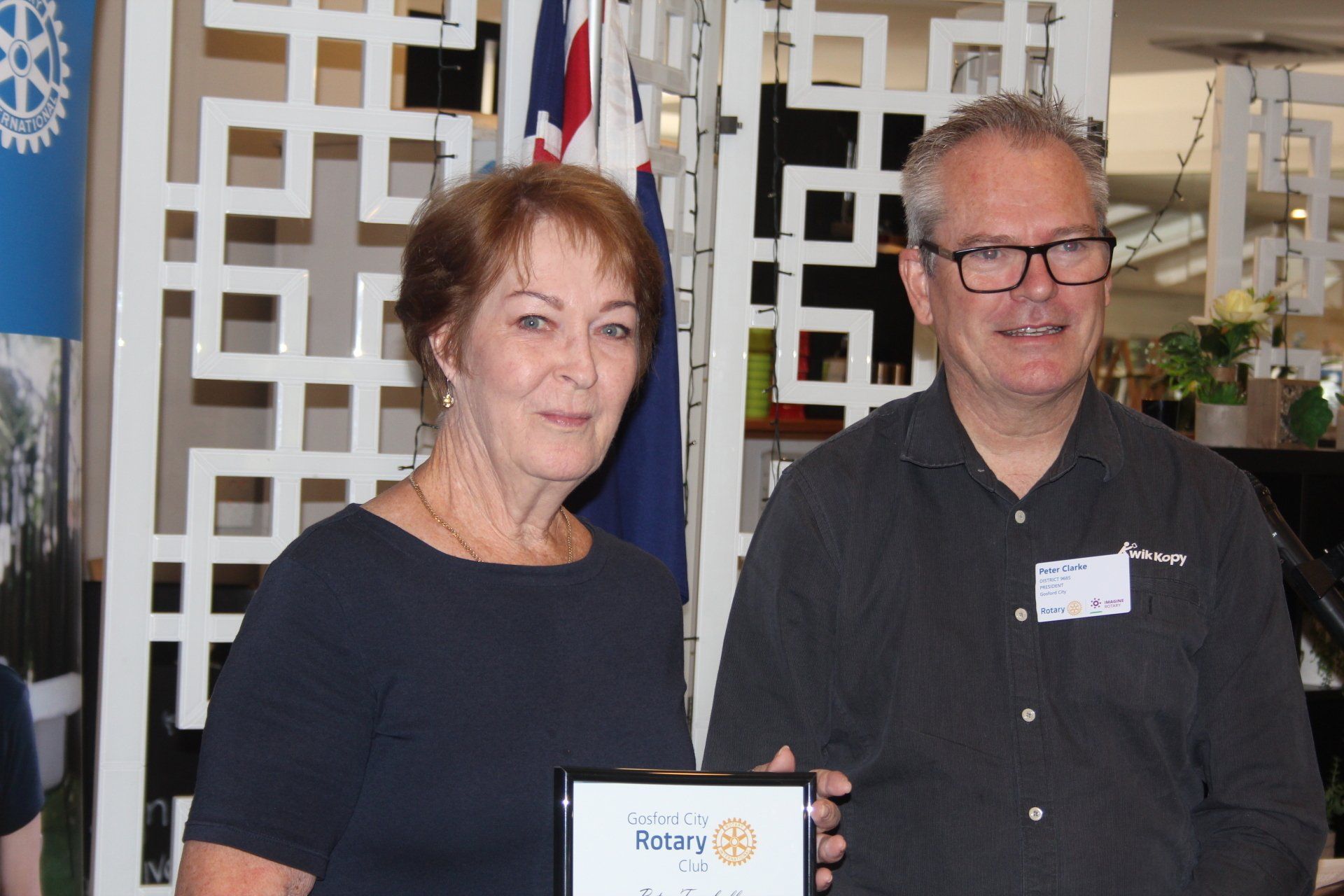 A man and a woman are standing next to each other holding a certificate.