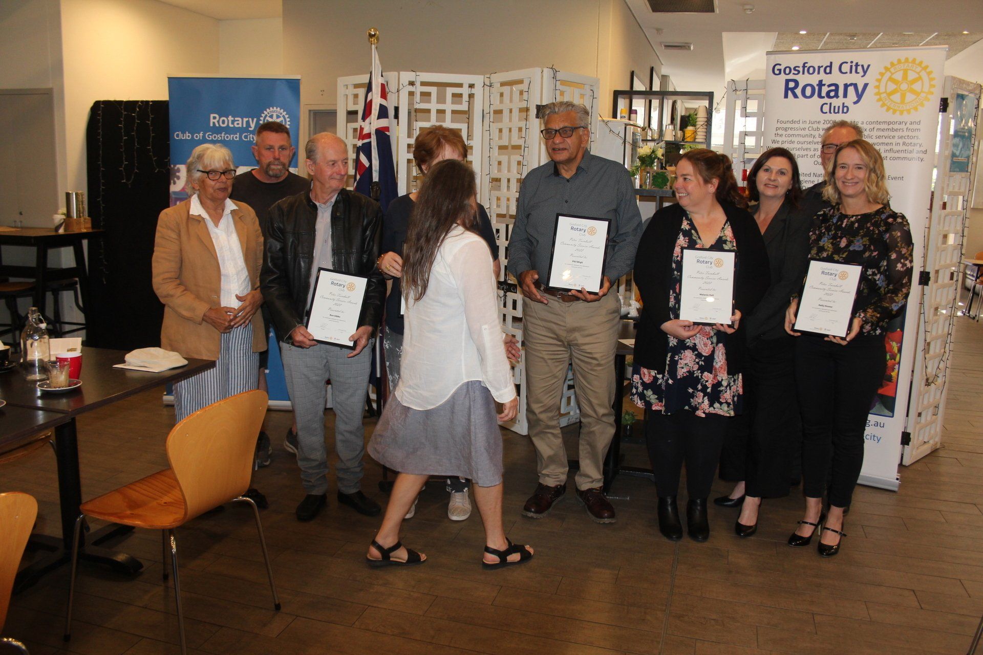 A group of people are standing in a room holding certificates.