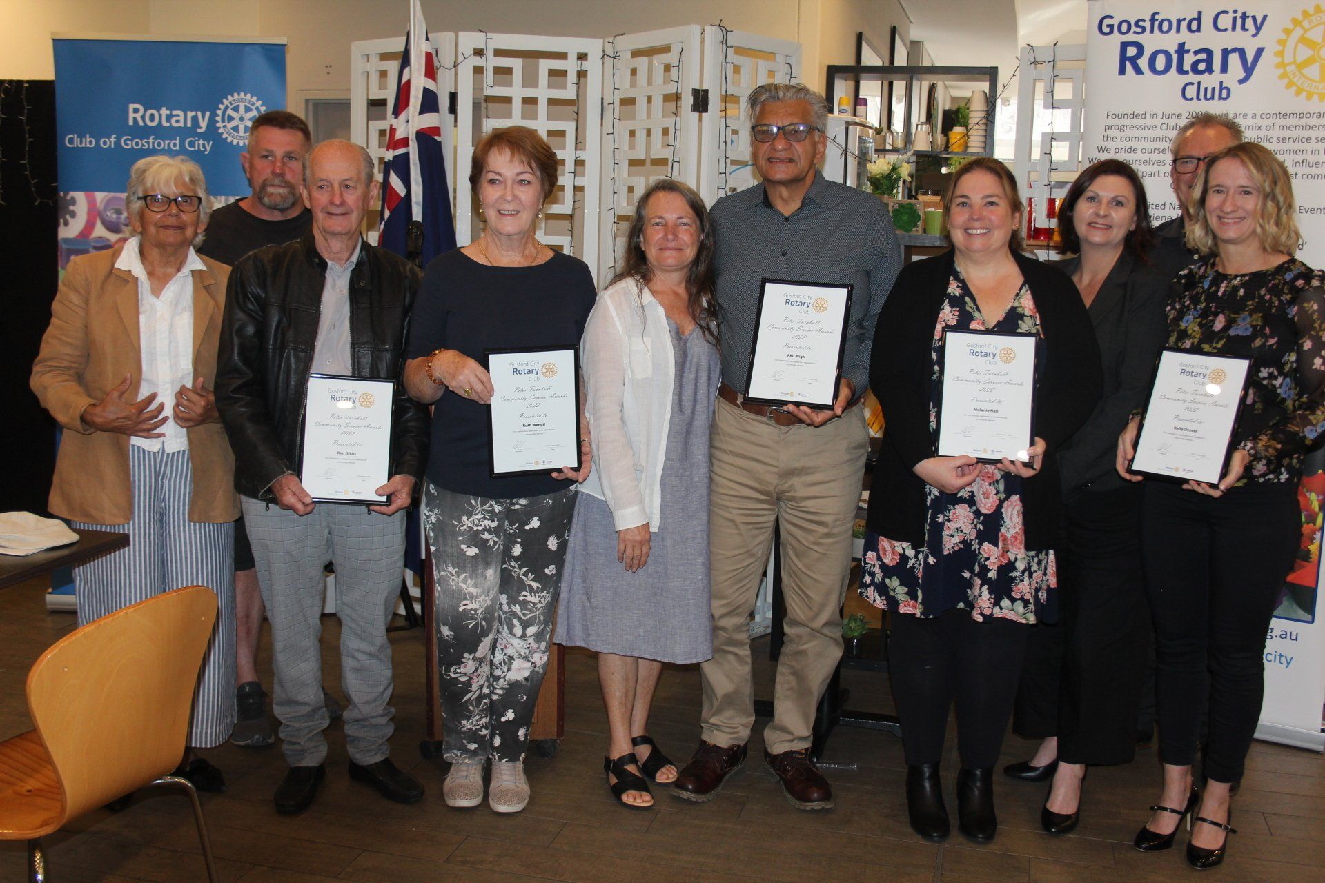 A group of people standing next to each other holding certificates.