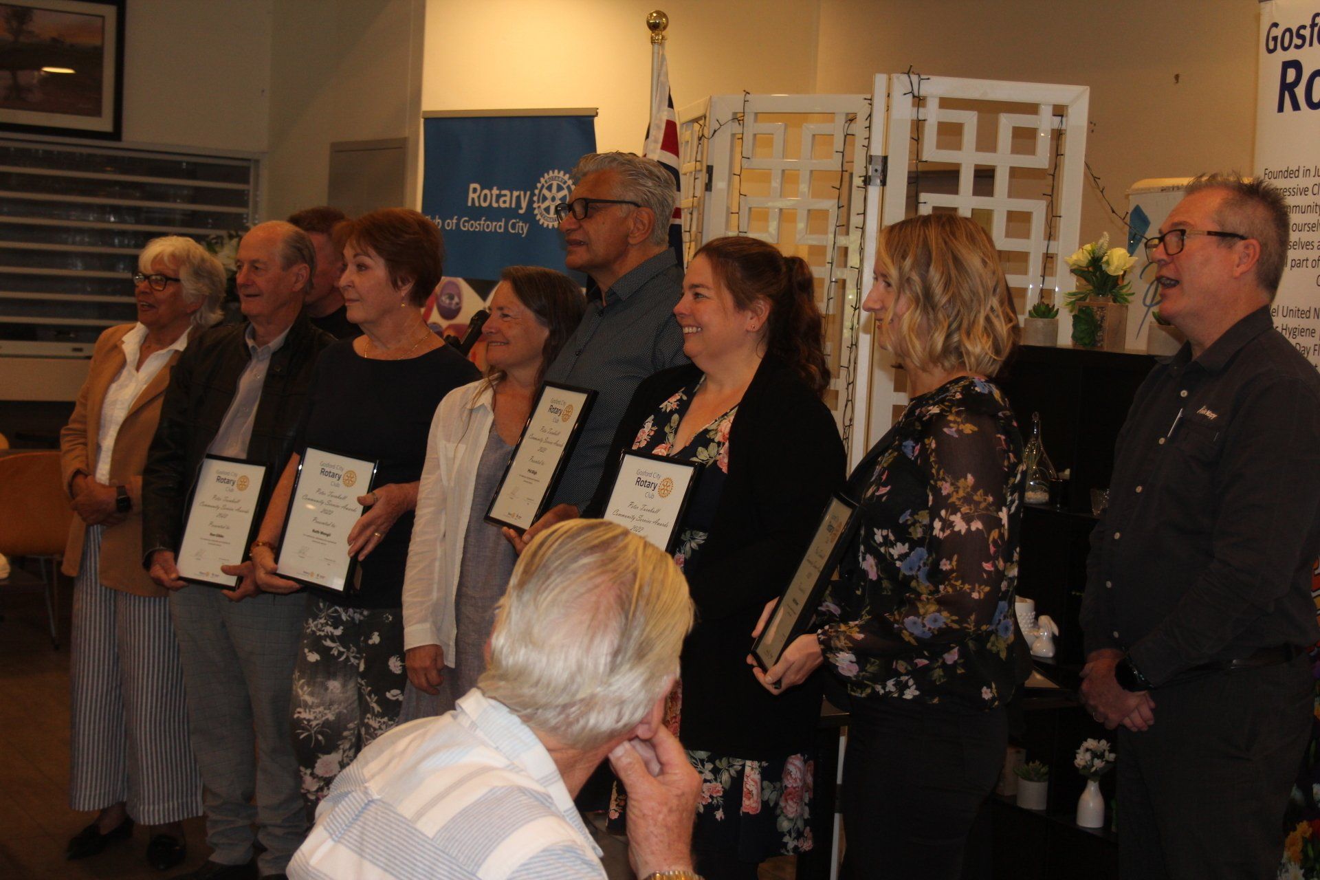 A group of people are standing in a line holding certificates.