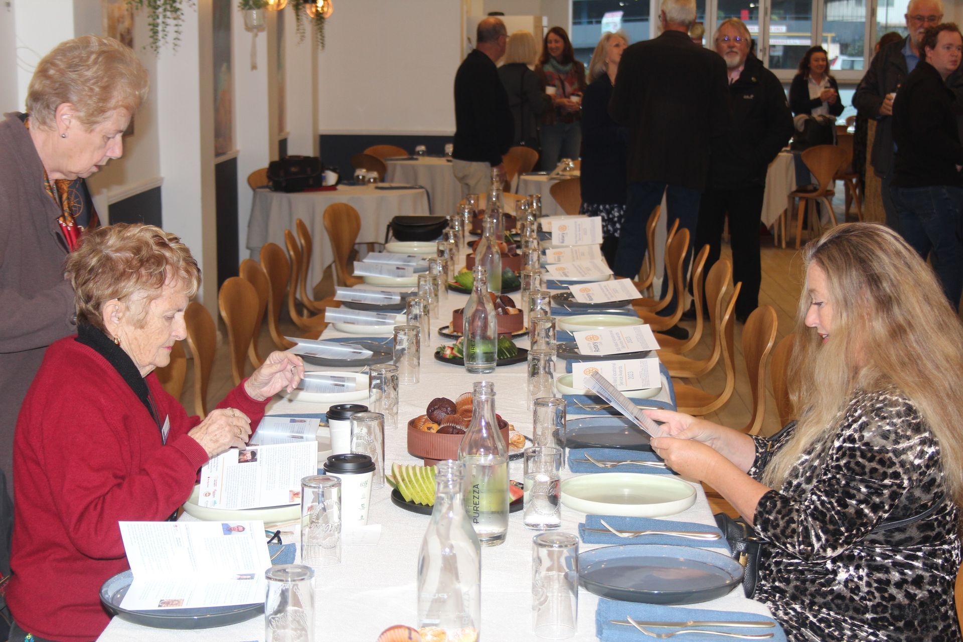 A group of people are sitting at a long table in a restaurant