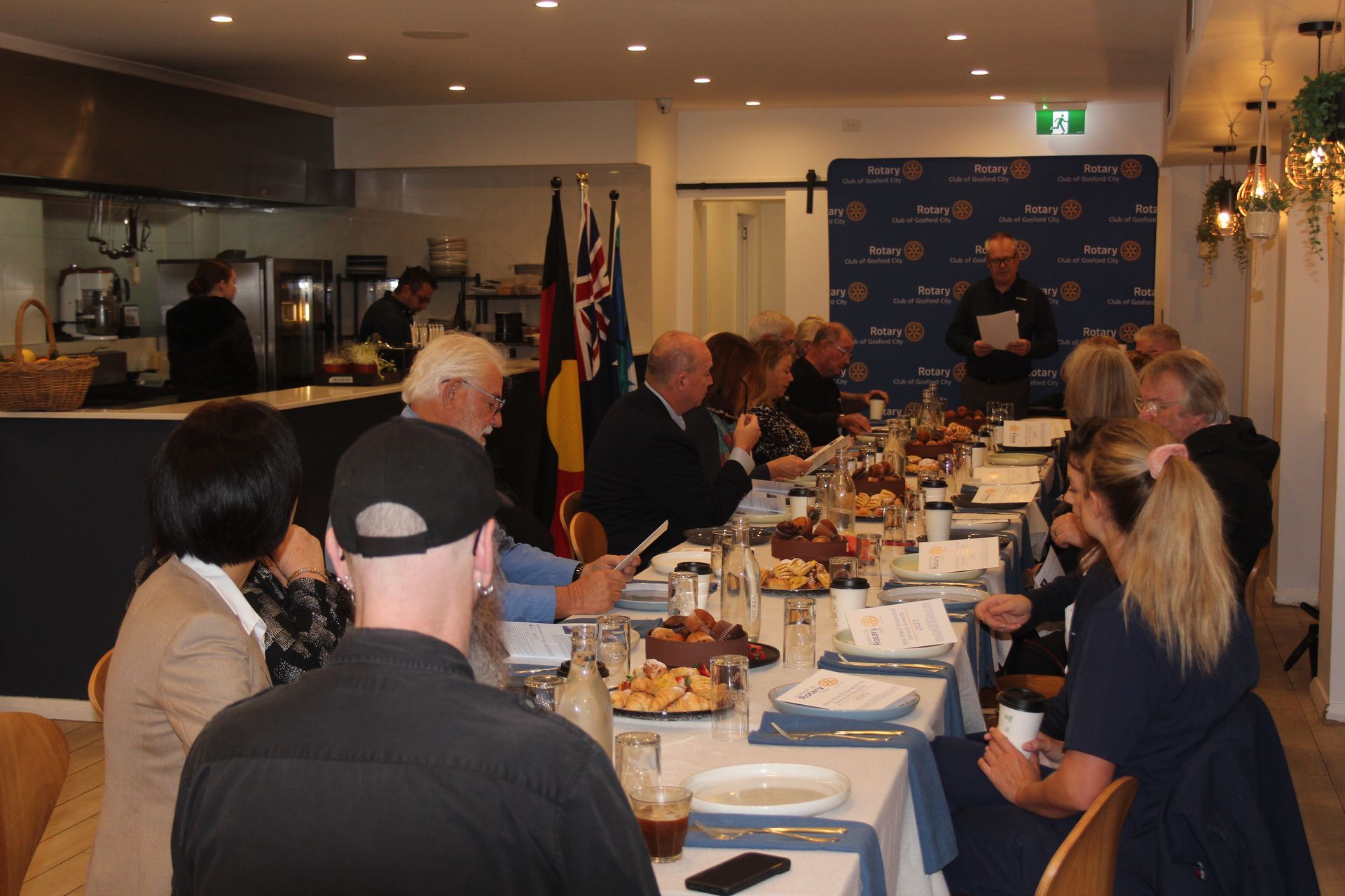 A group of people are sitting at a long table in a restaurant.