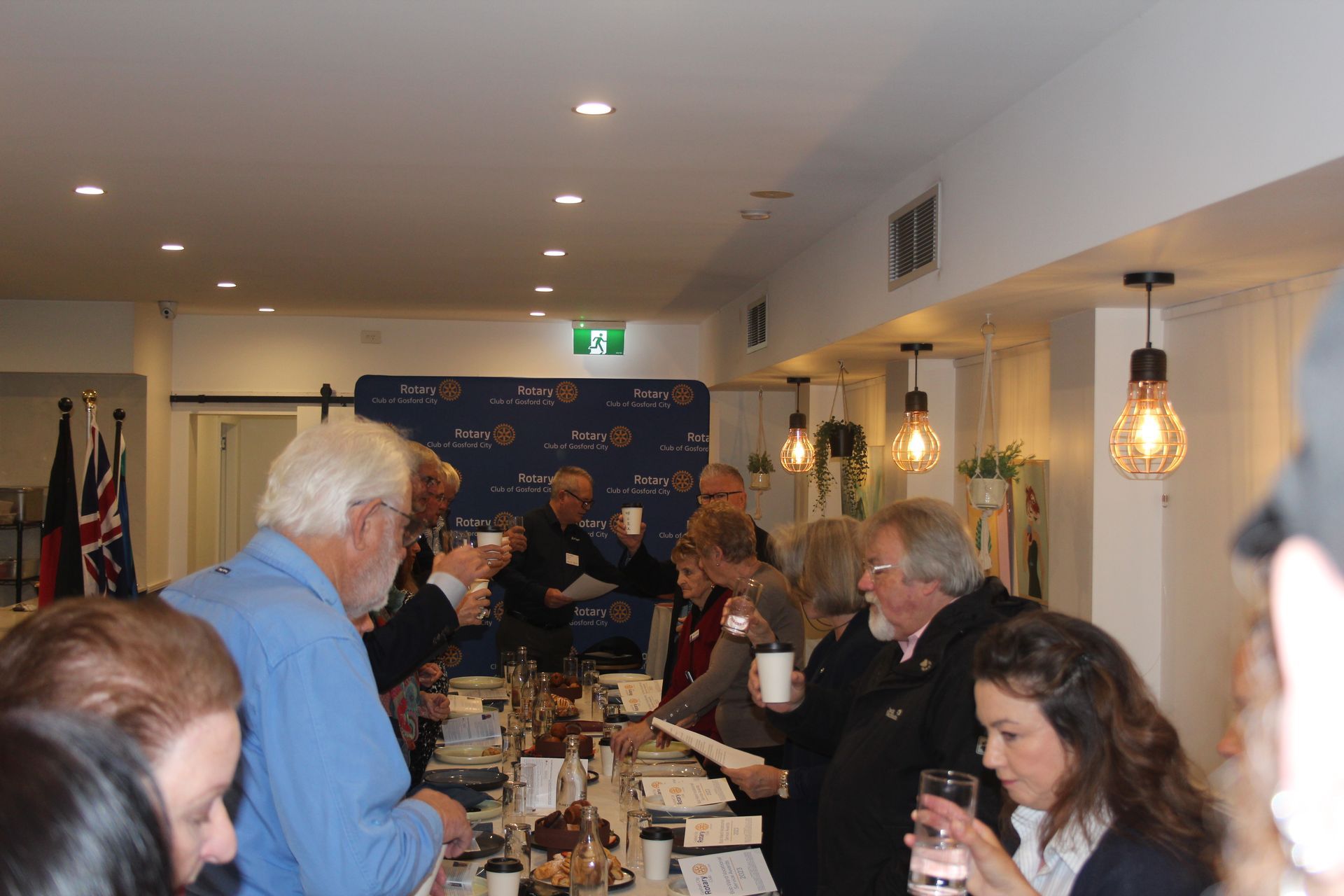 A group of people are sitting at a long table in a room.