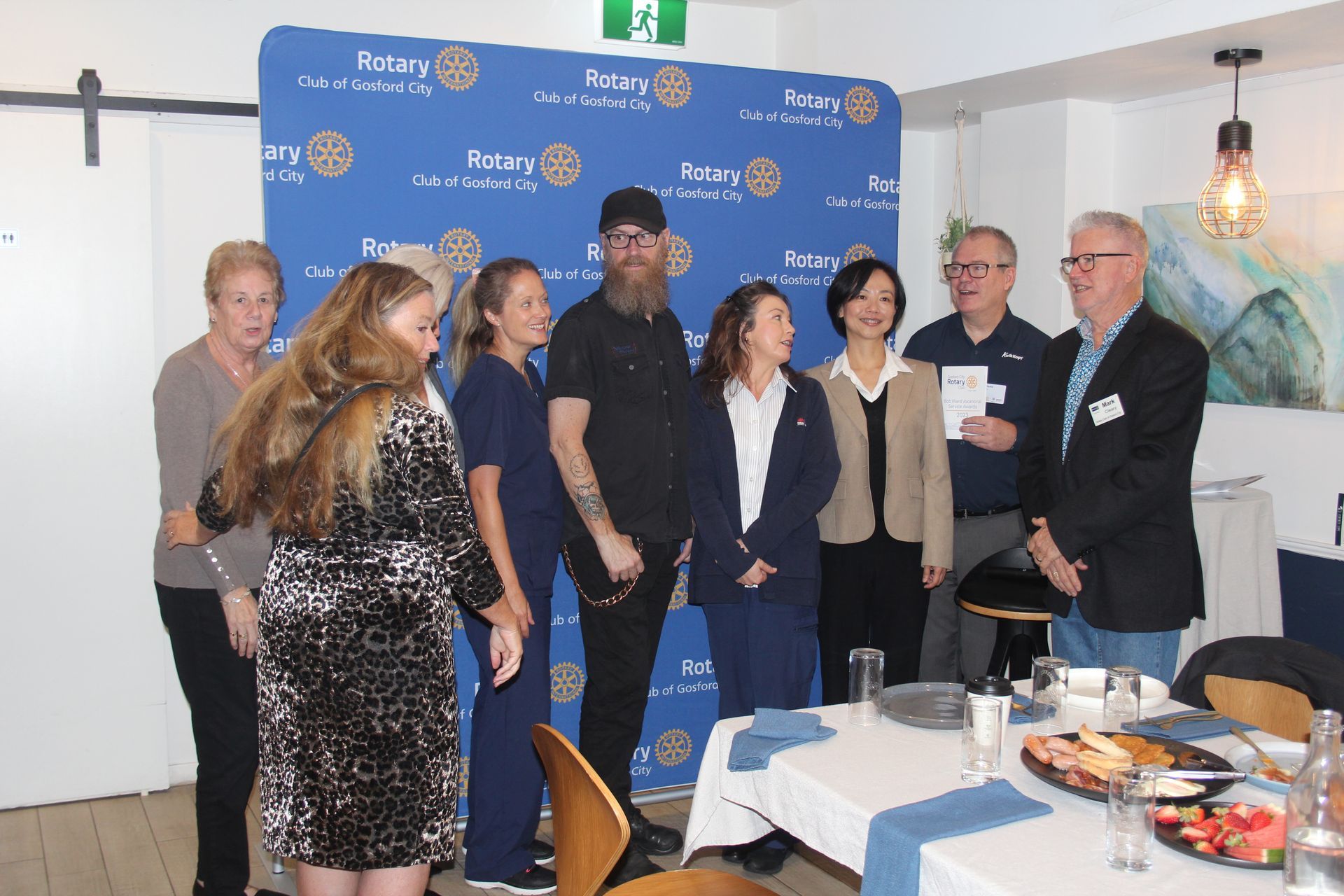 A group of people are standing around a table in a room.