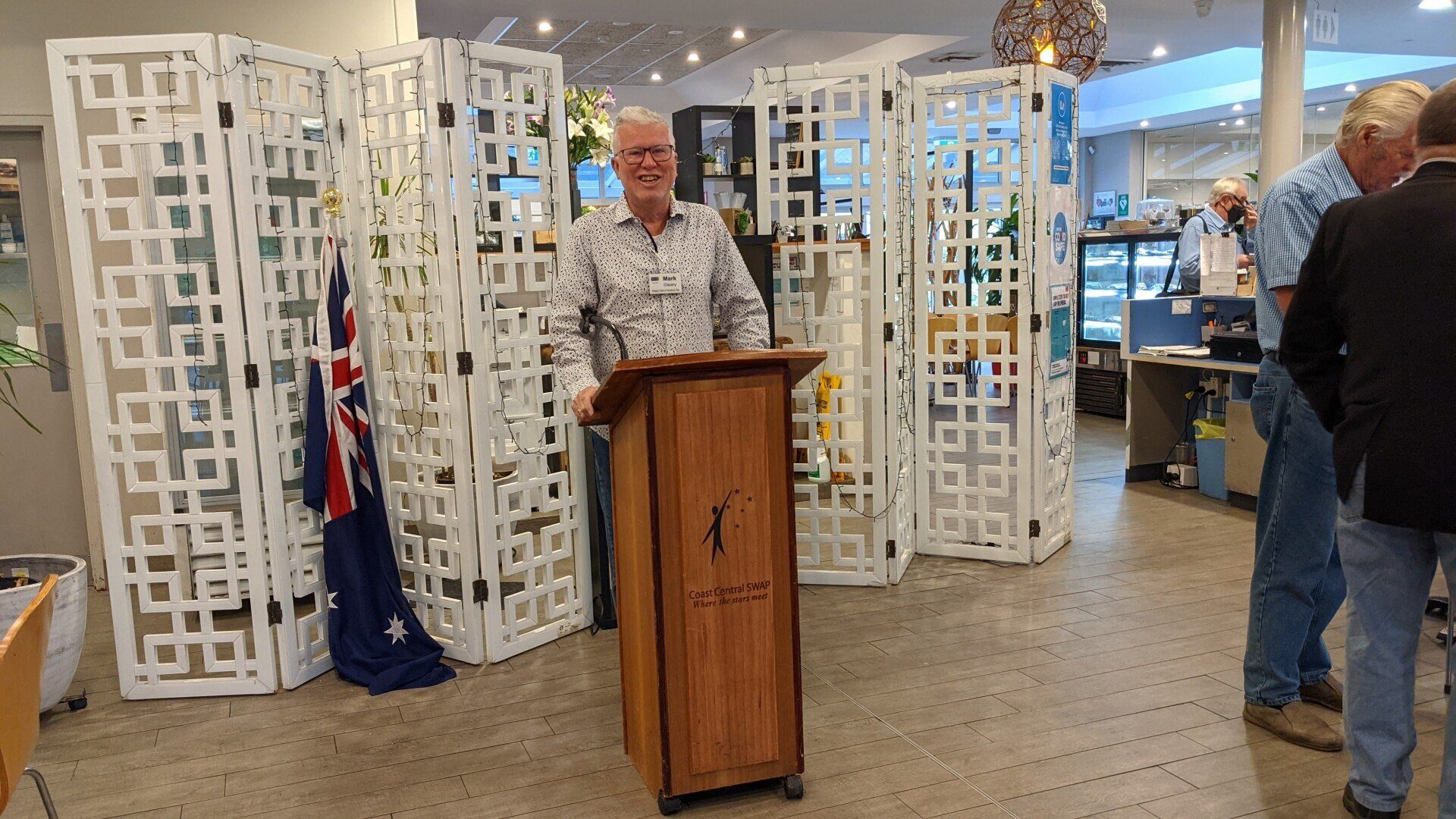 A man is standing at a podium giving a speech in a room.