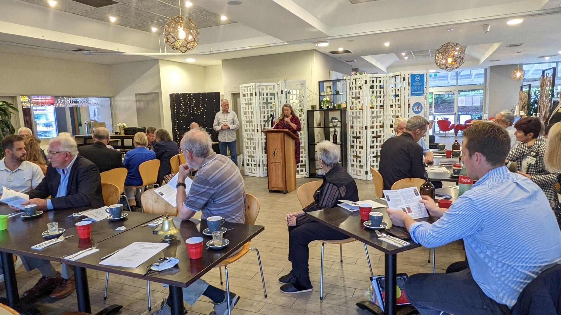 A group of people are sitting at tables in a room.