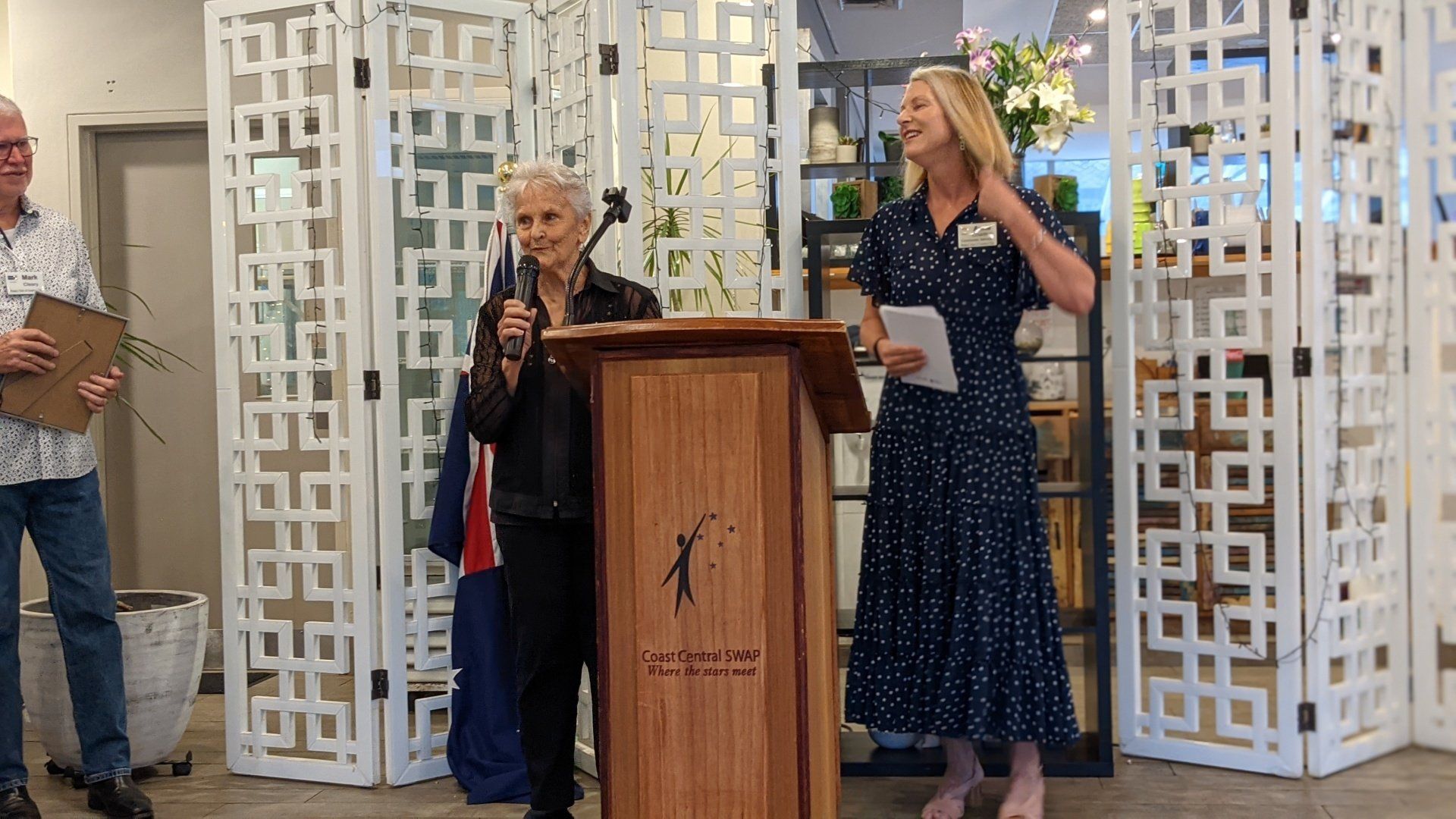 Two women are standing at a podium giving a speech.