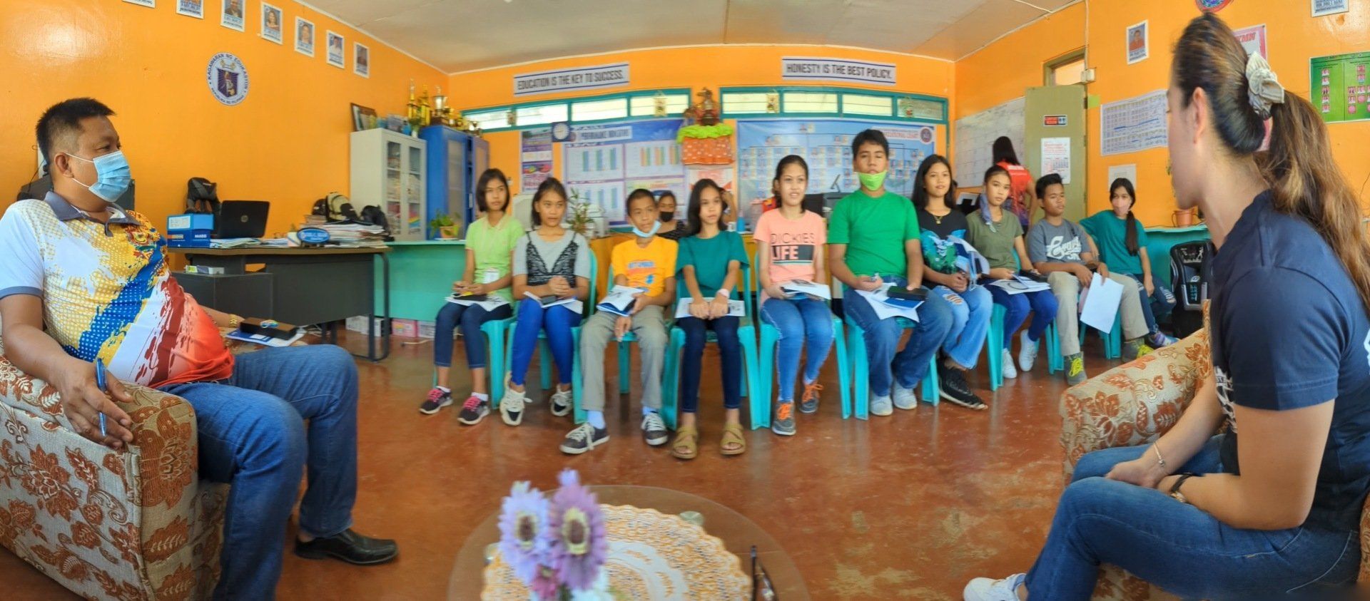 A group of people are sitting in a room and talking to each other.