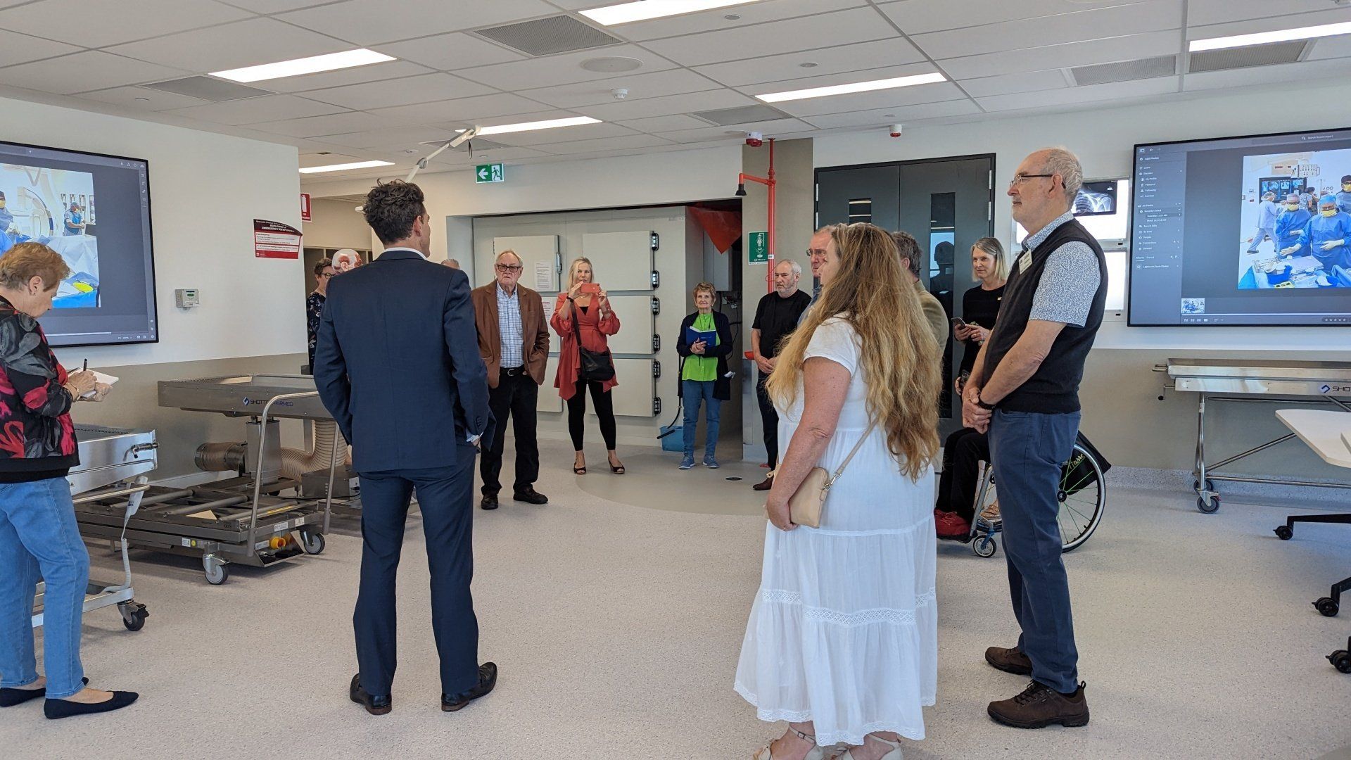 A group of people are standing in a room talking to each other.