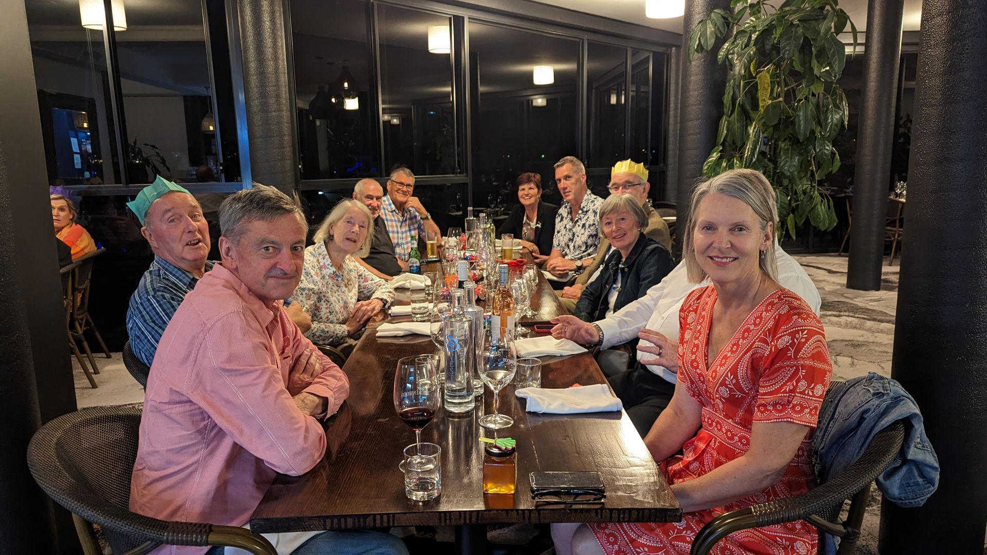 A group of people are sitting at a long table in a restaurant.