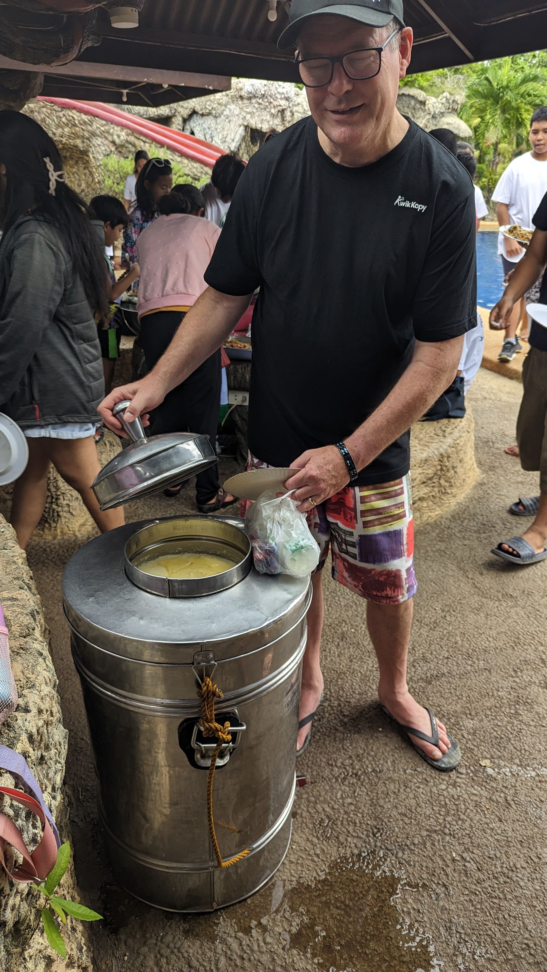 A man is standing next to a large metal container.