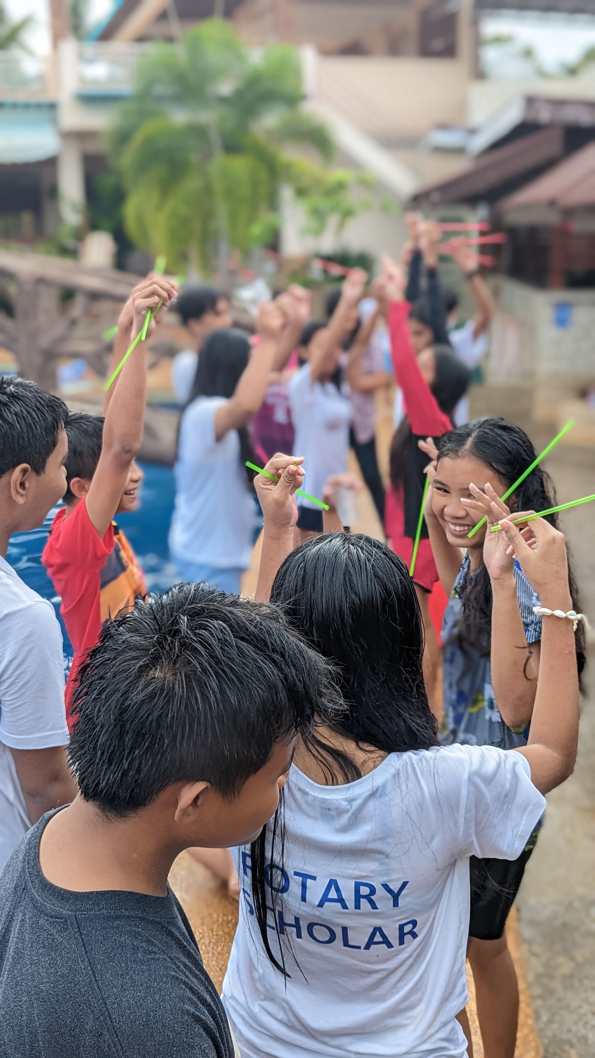 A group of children are playing with straws in a park.