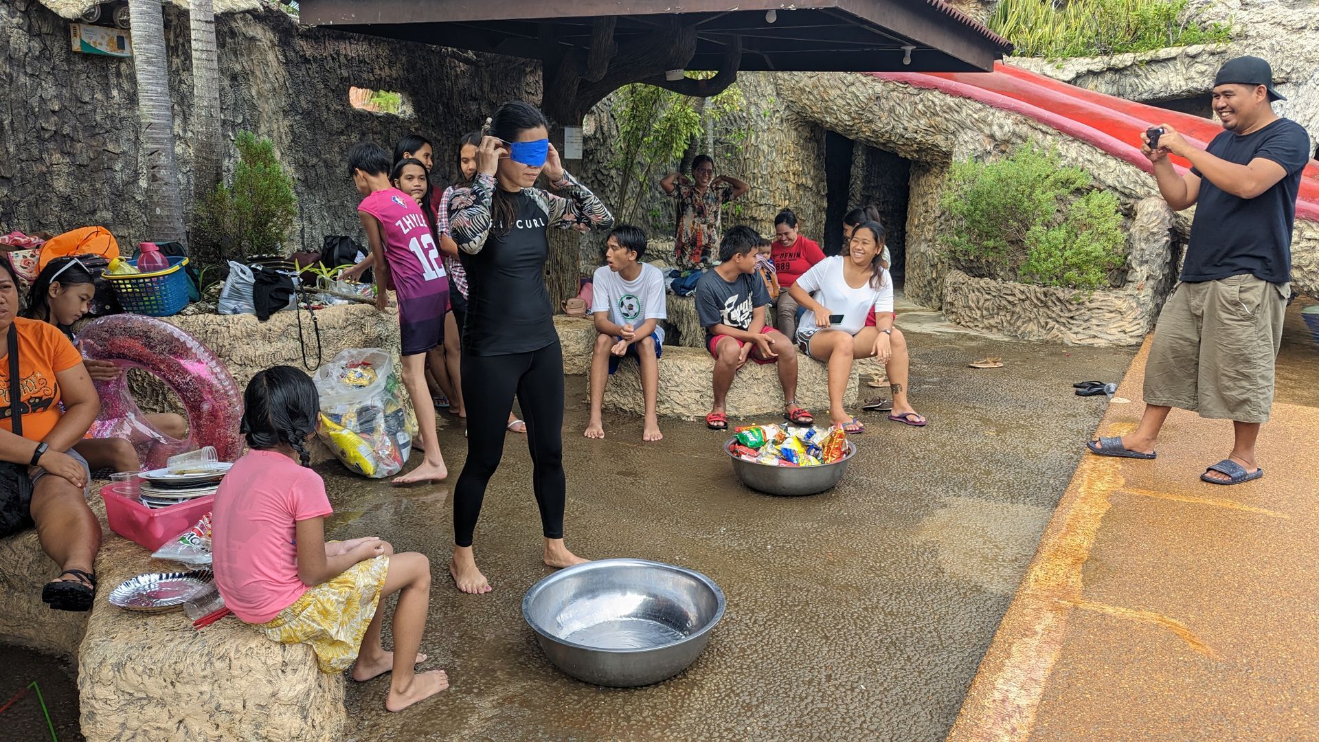 A group of people are playing with water balloons in a park.