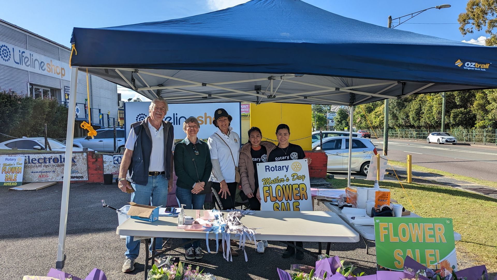 A group of people are standing in front of a tent.