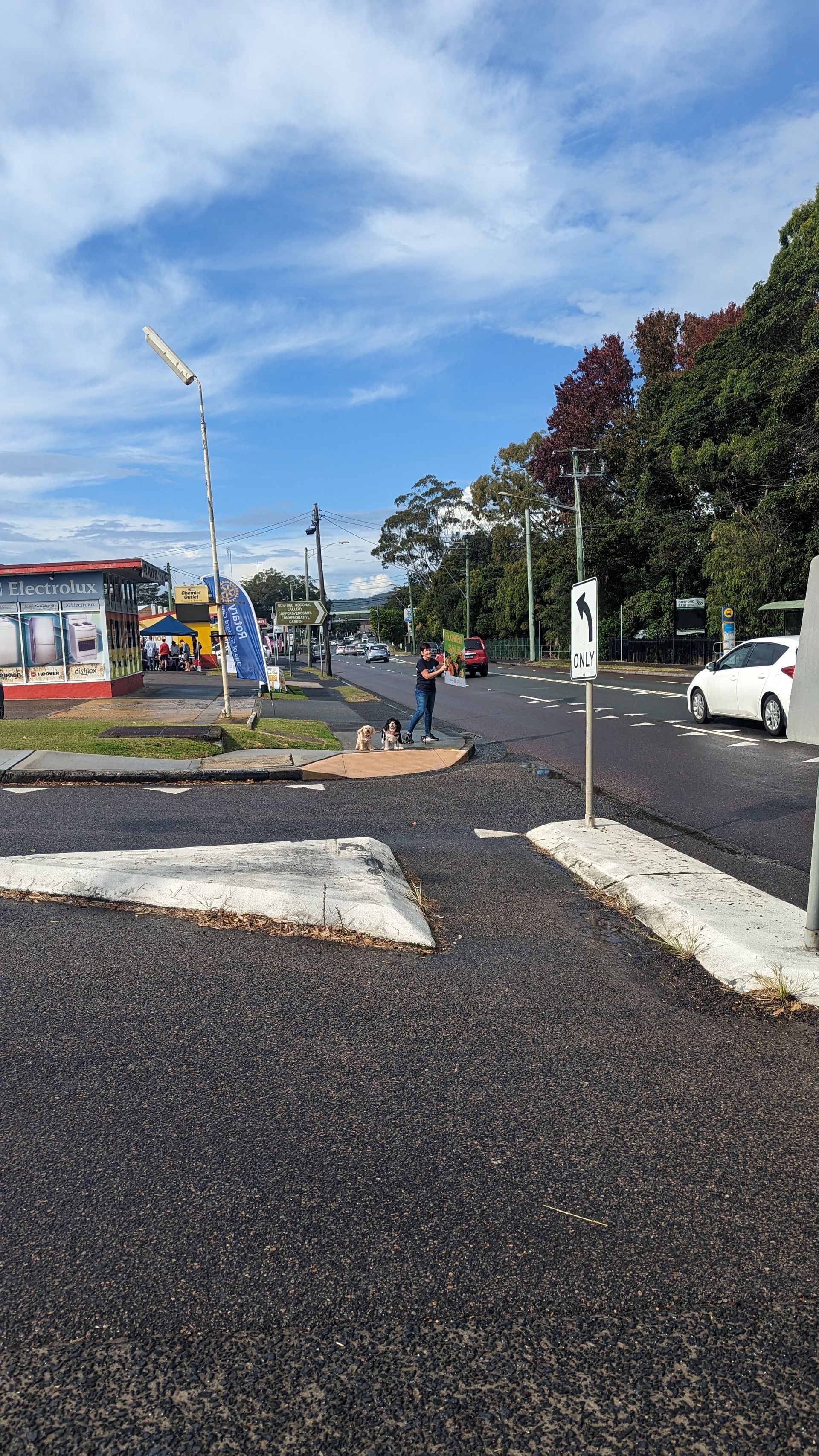 A person is walking down a street in a parking lot.