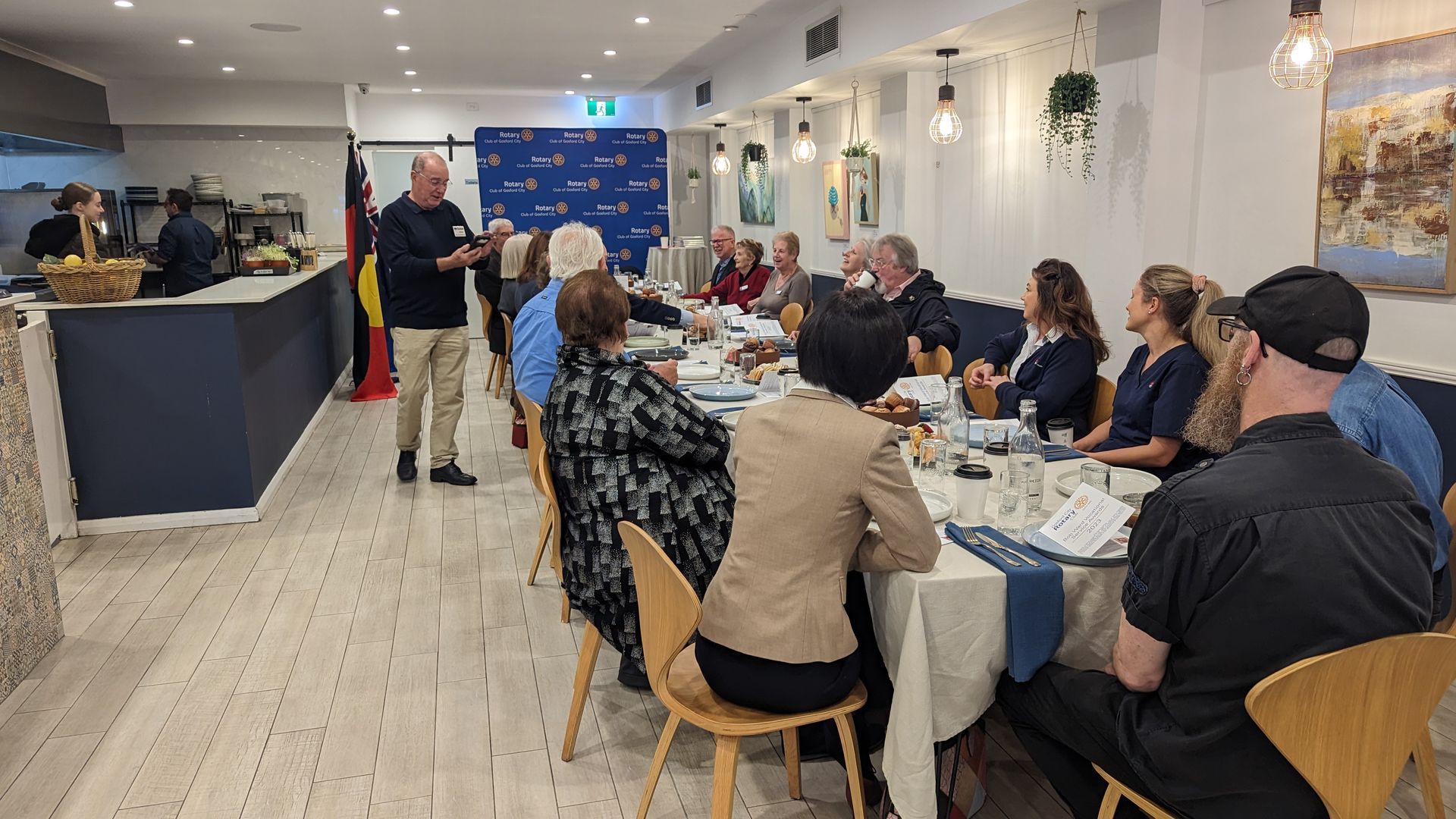 A group of people are sitting at tables in a restaurant.