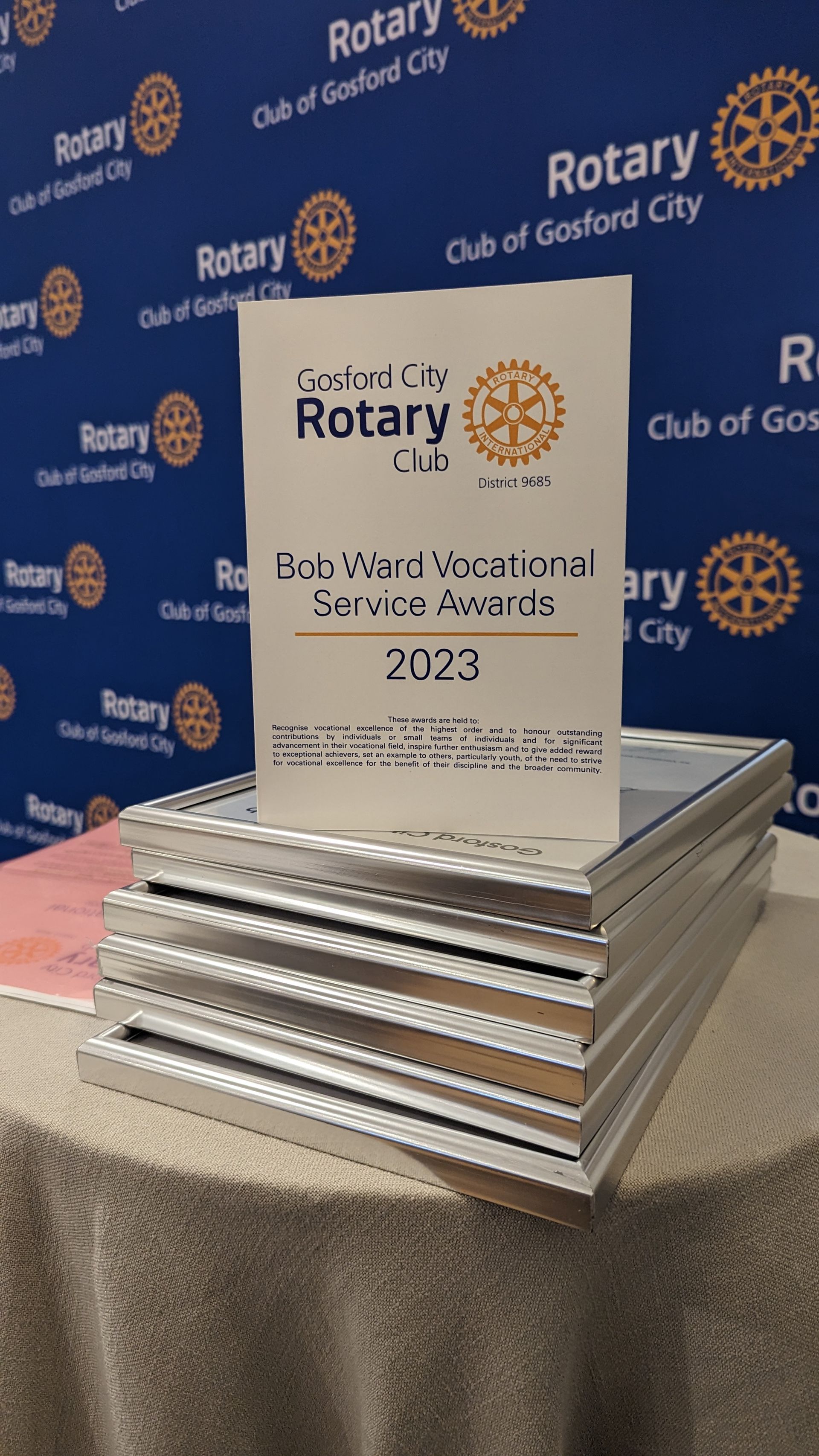A stack of rotary awards sitting on top of a table.