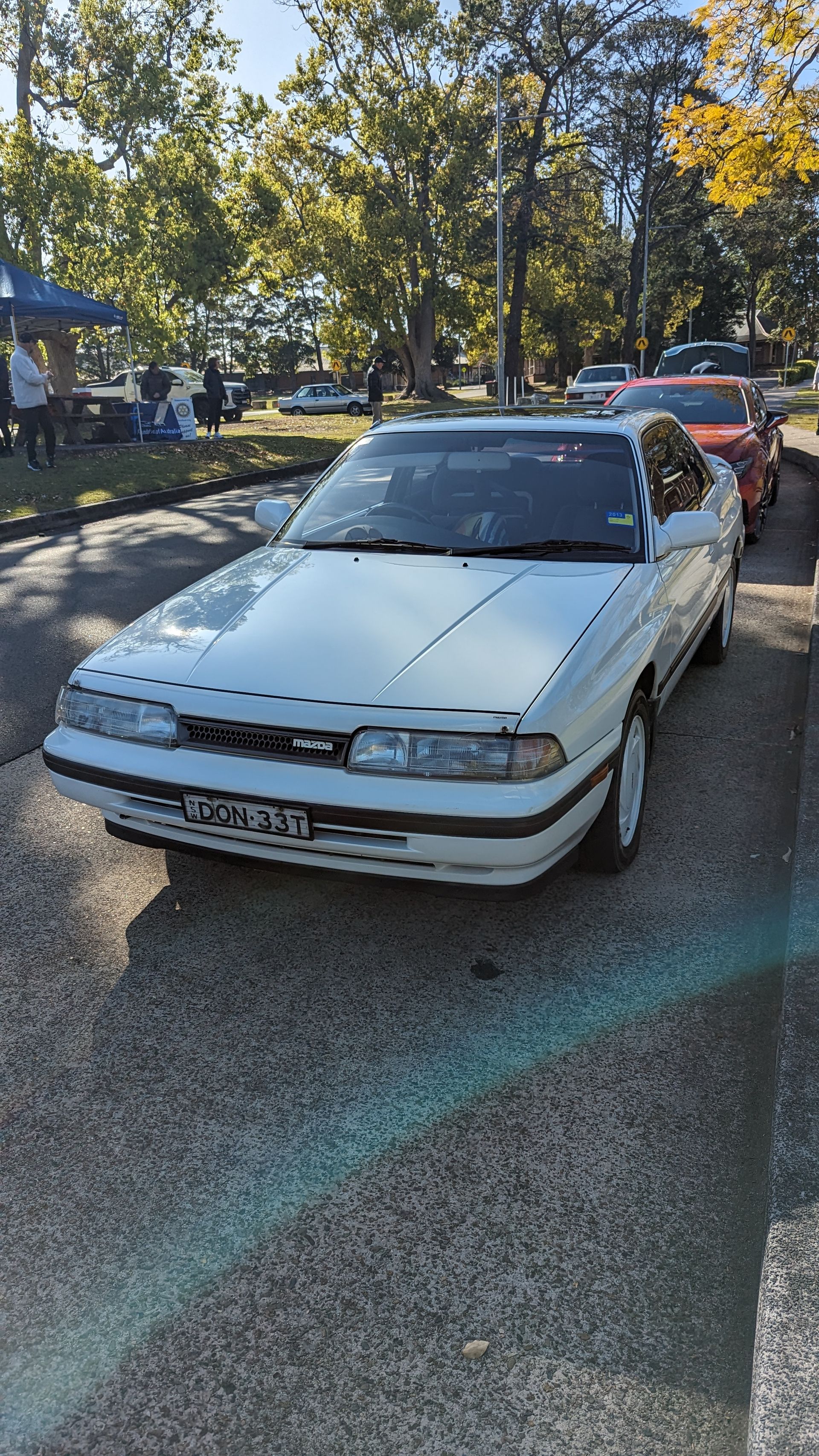 A white car is parked on the side of the road.