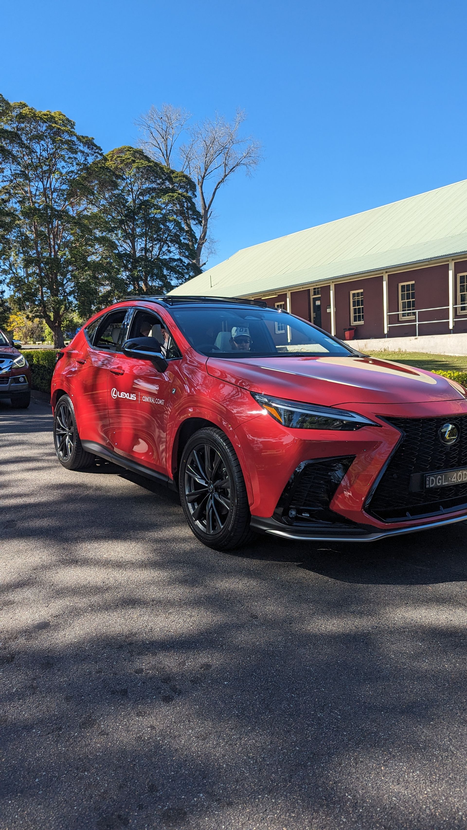 A red car is parked in front of a building.
