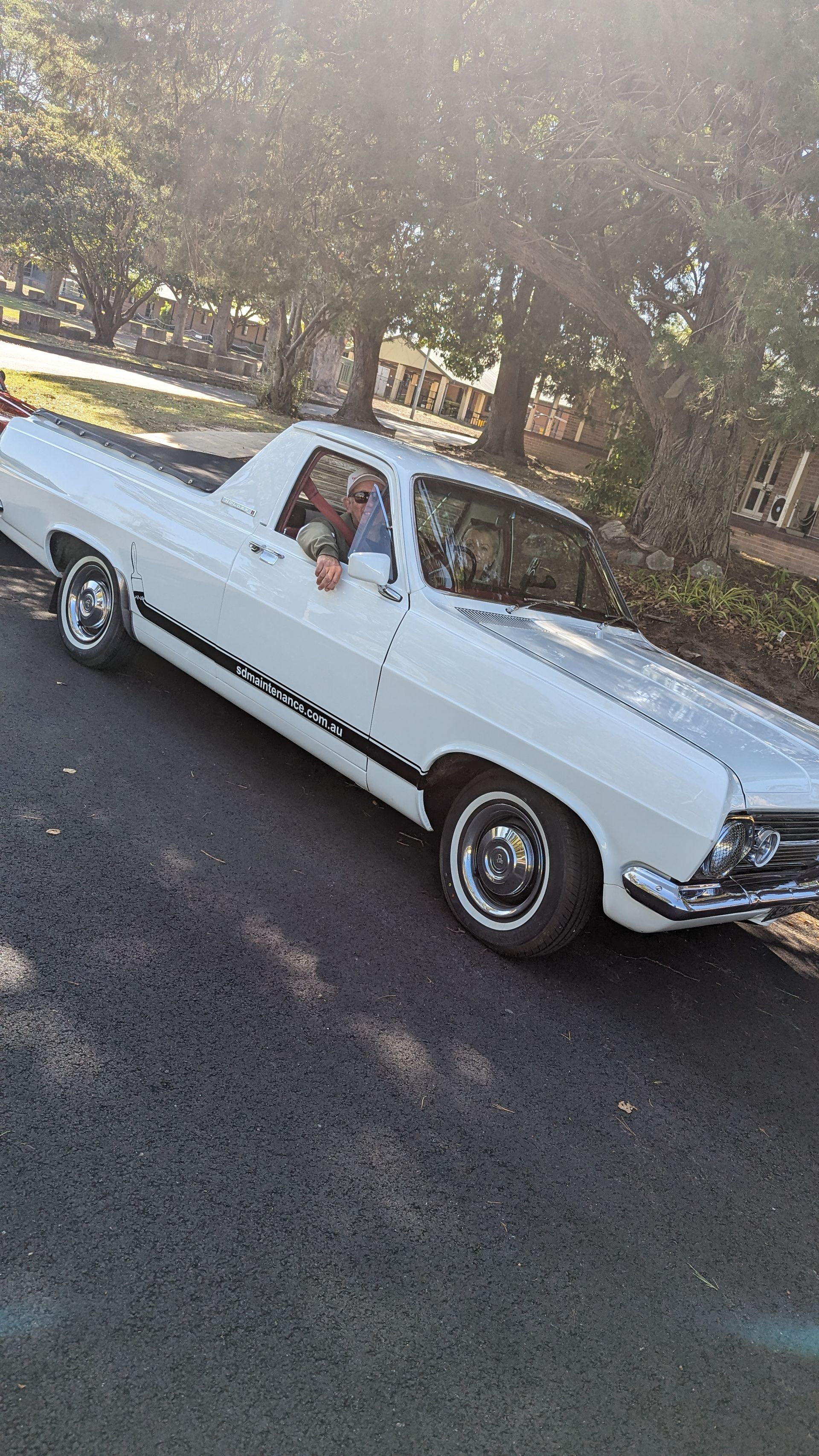 A white pickup truck is parked on the side of the road.
