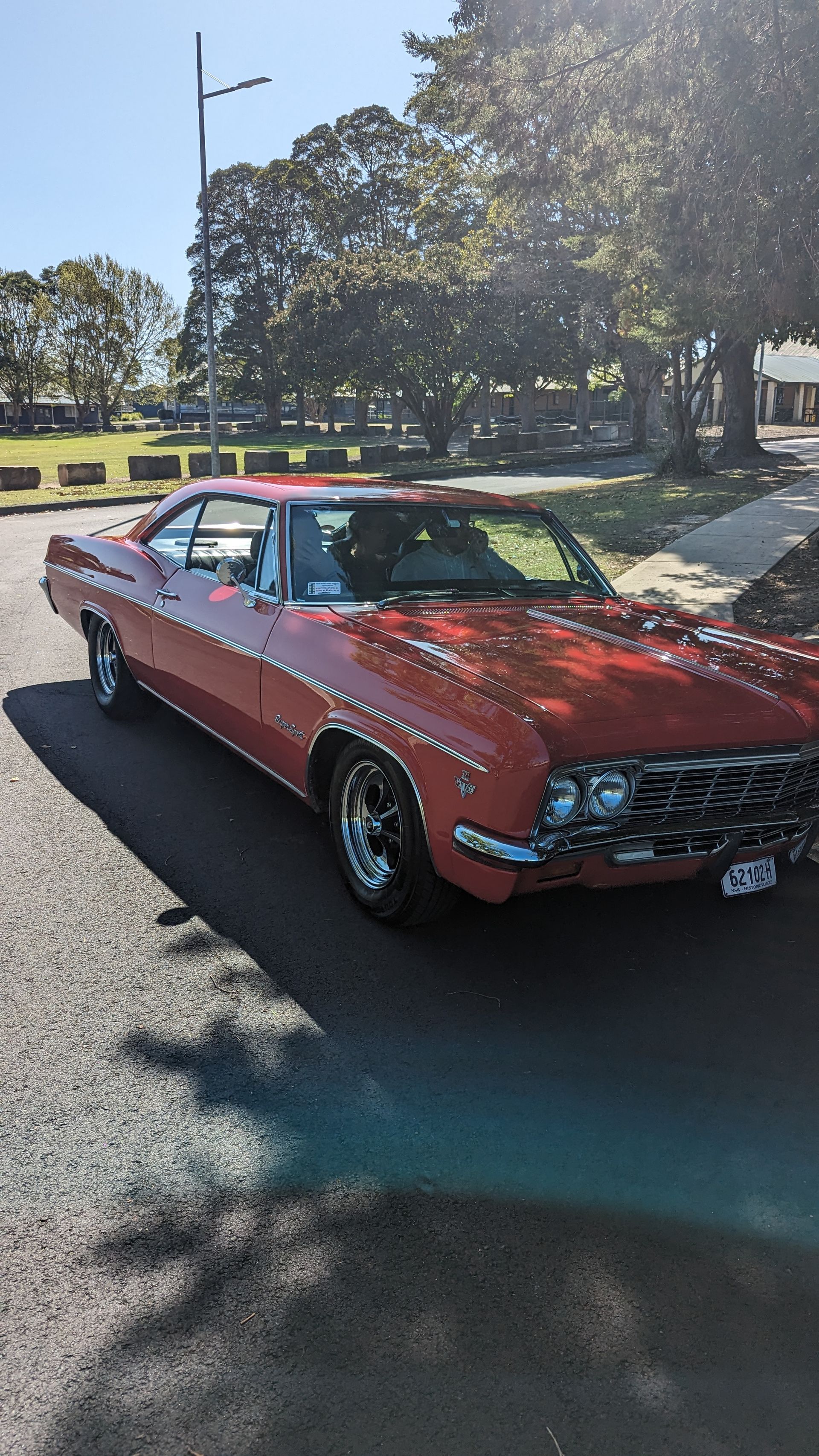 A red car is parked on the side of the road.