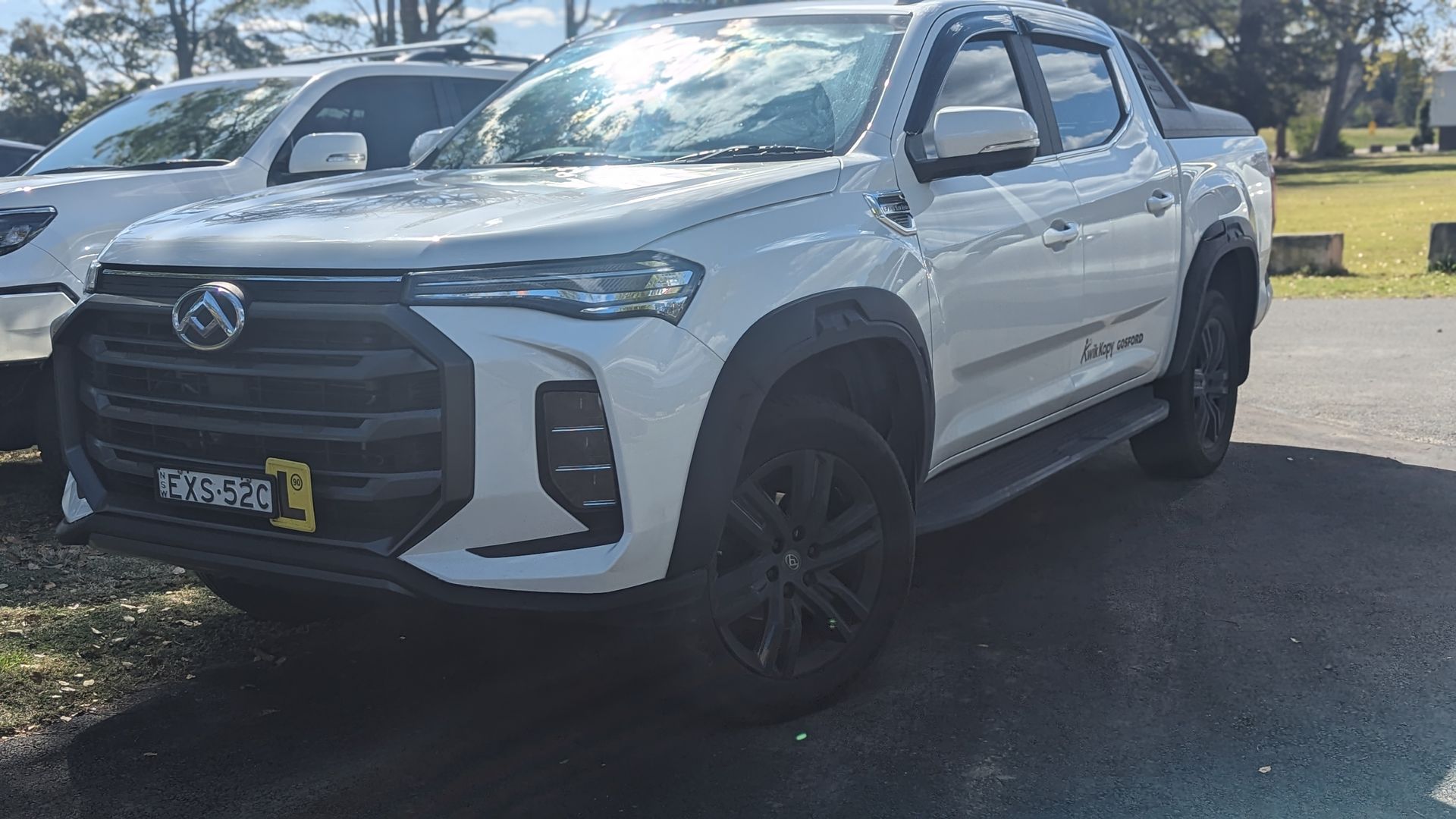 A white pickup truck is parked in a parking lot.