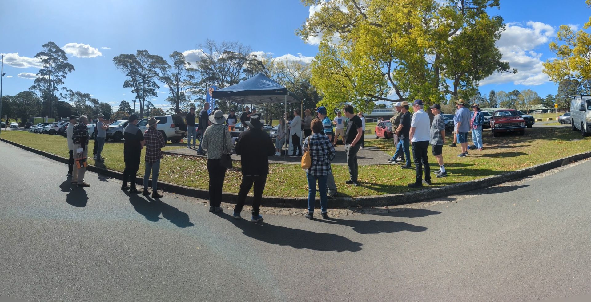 A group of people are standing on the side of a road.