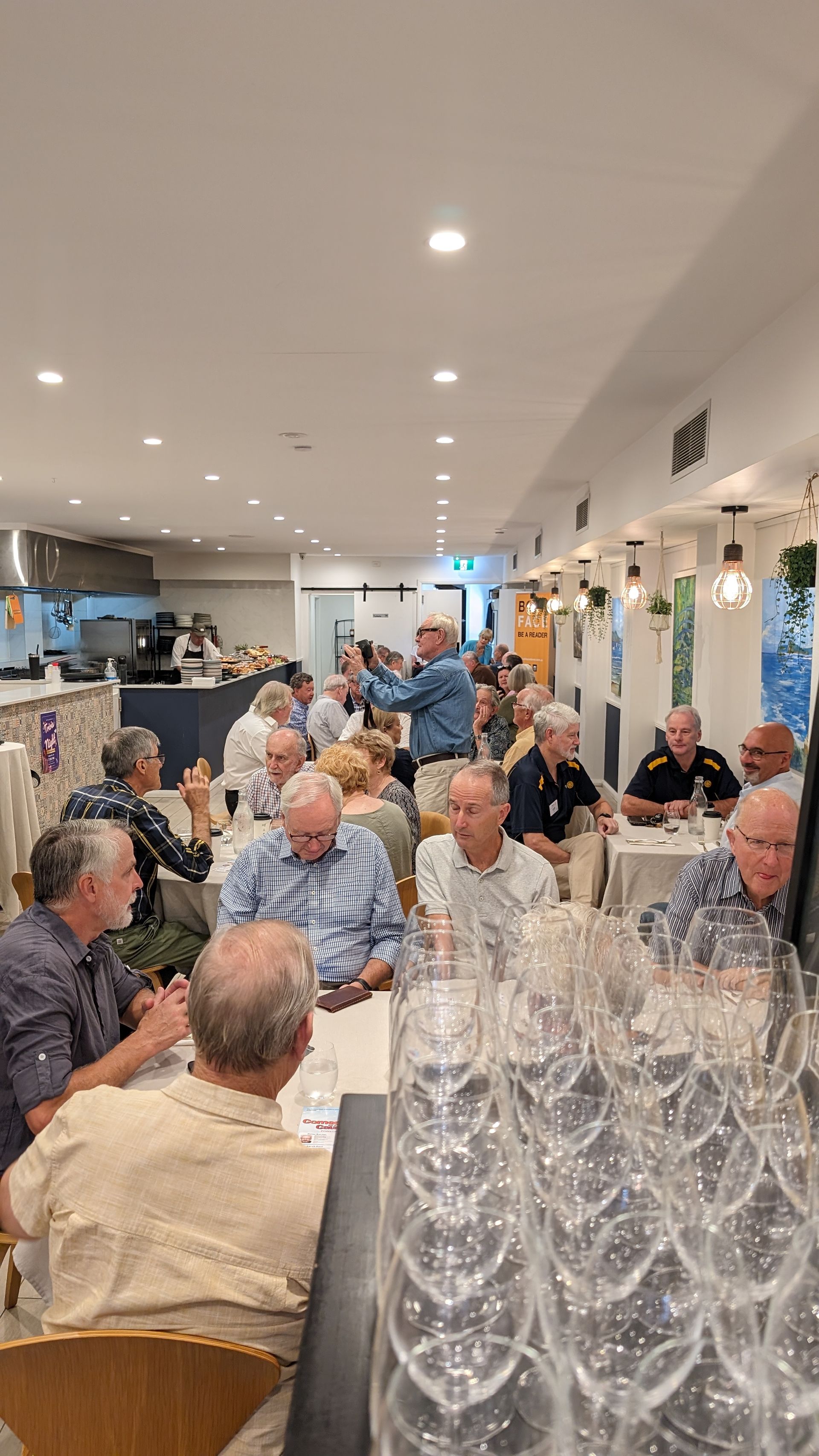A group of people are sitting at tables in a restaurant.