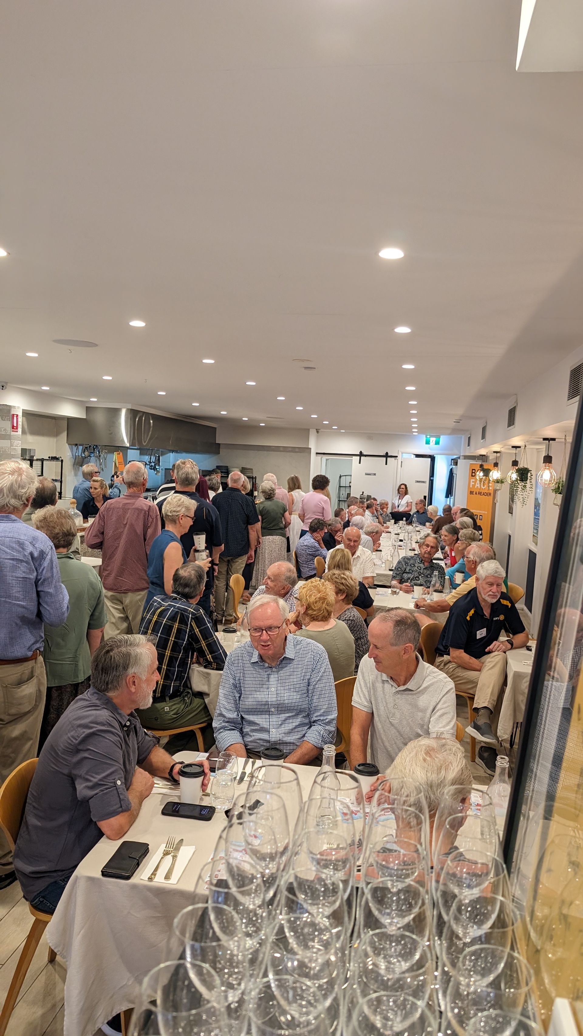 A large group of people are sitting at tables in a restaurant.