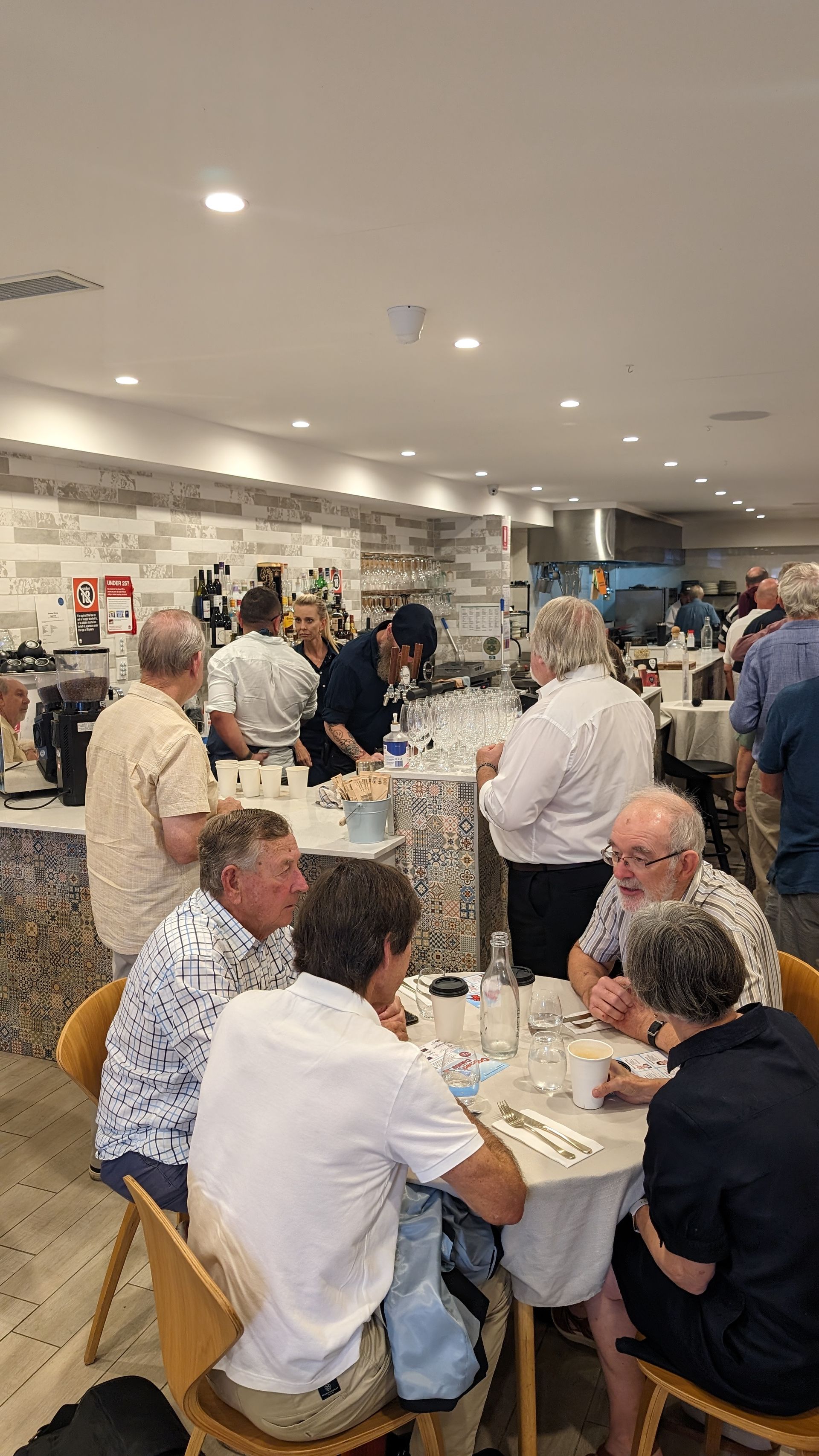 A group of people are sitting at tables in a restaurant.