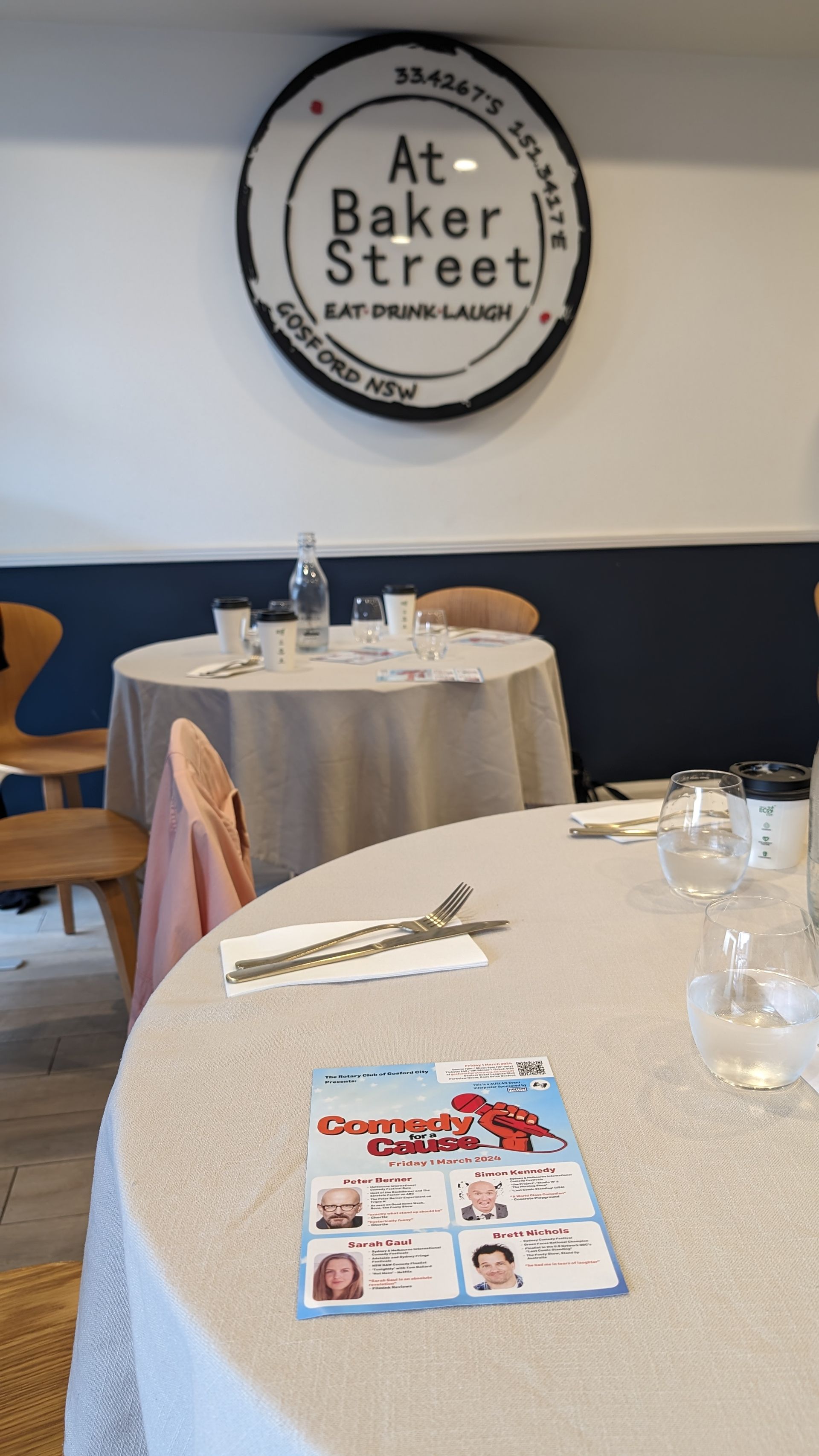 A restaurant with tables and chairs and a sign that says at baker street