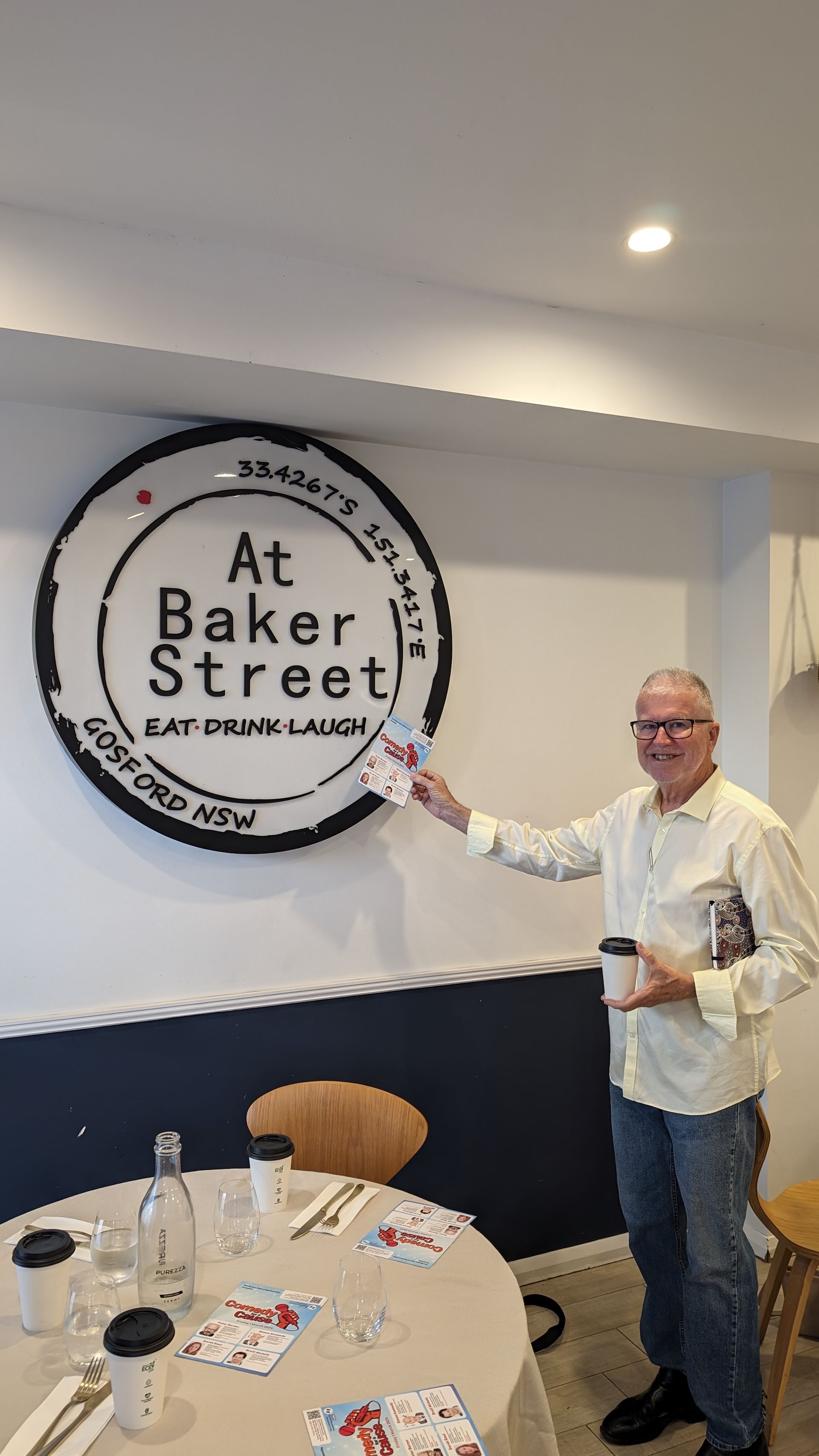 A man is standing in front of a sign that says at baker street.