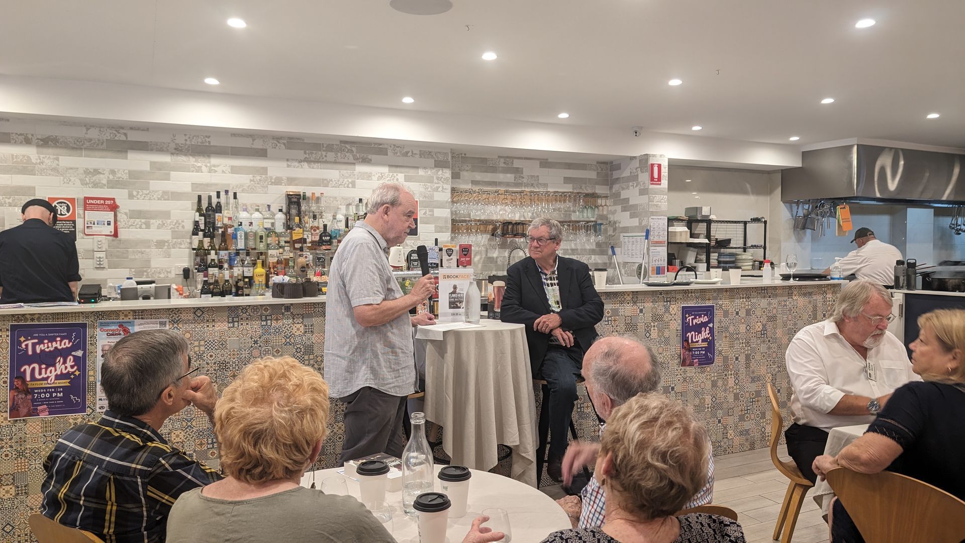 A group of people are sitting at tables in a restaurant.