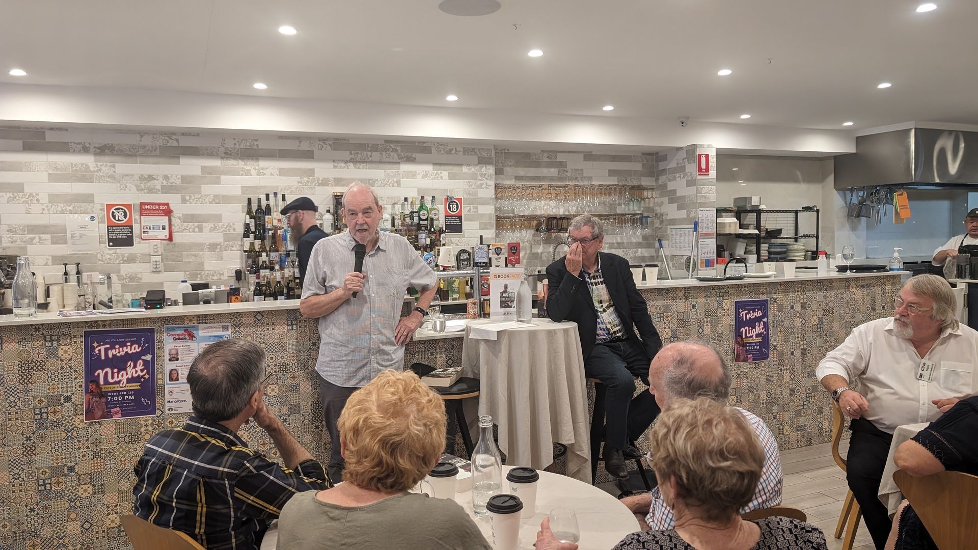 A group of people are sitting around a table in a restaurant.