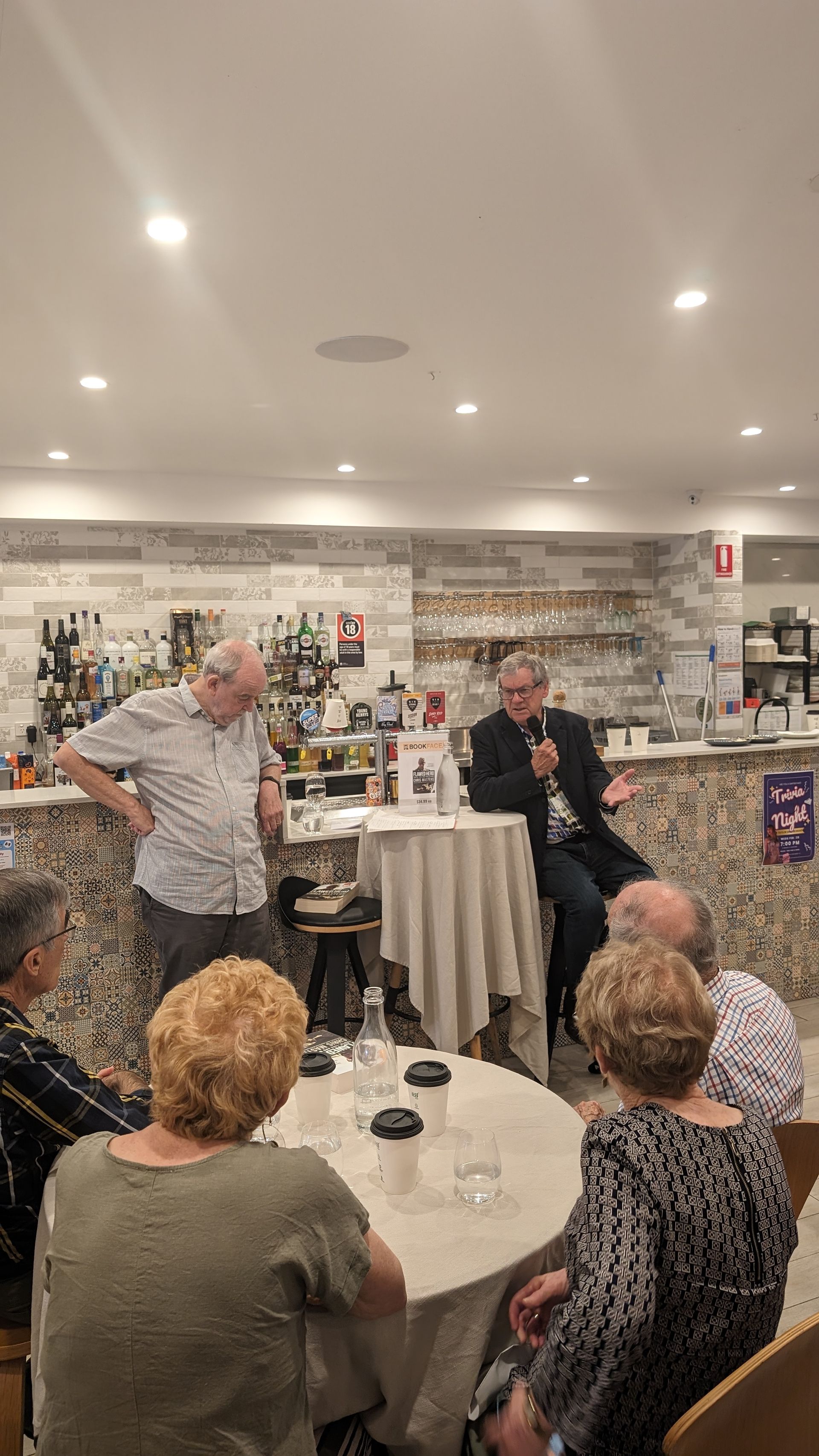 A group of people are sitting at tables in a restaurant.