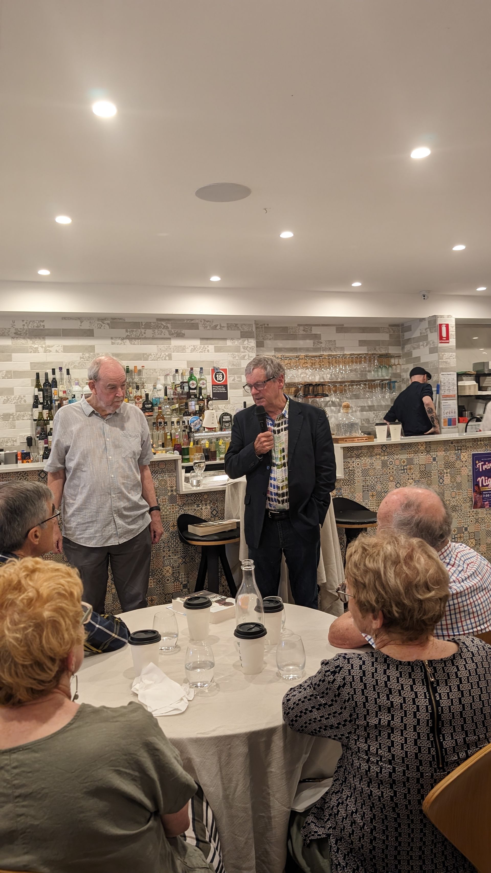 A group of people are sitting around a table in a restaurant.
