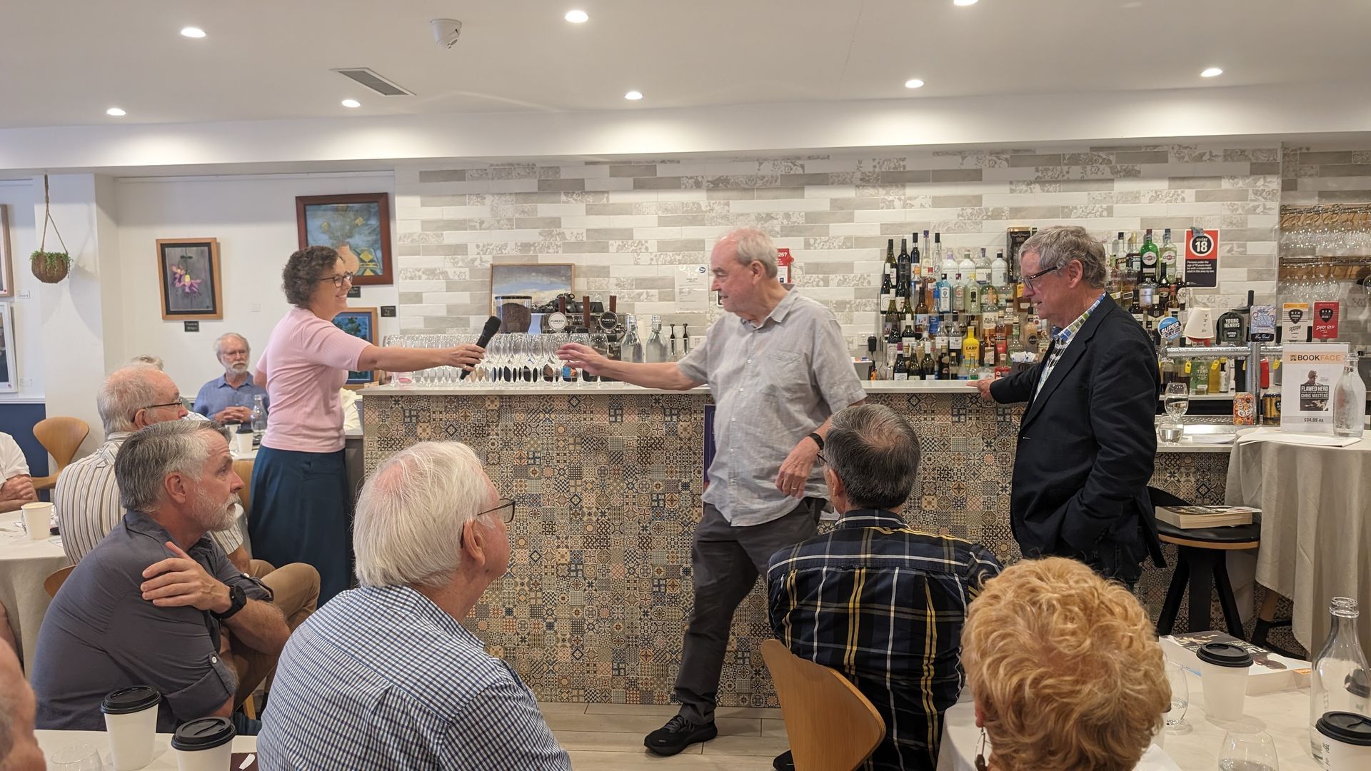 A group of people are sitting at tables in a restaurant.