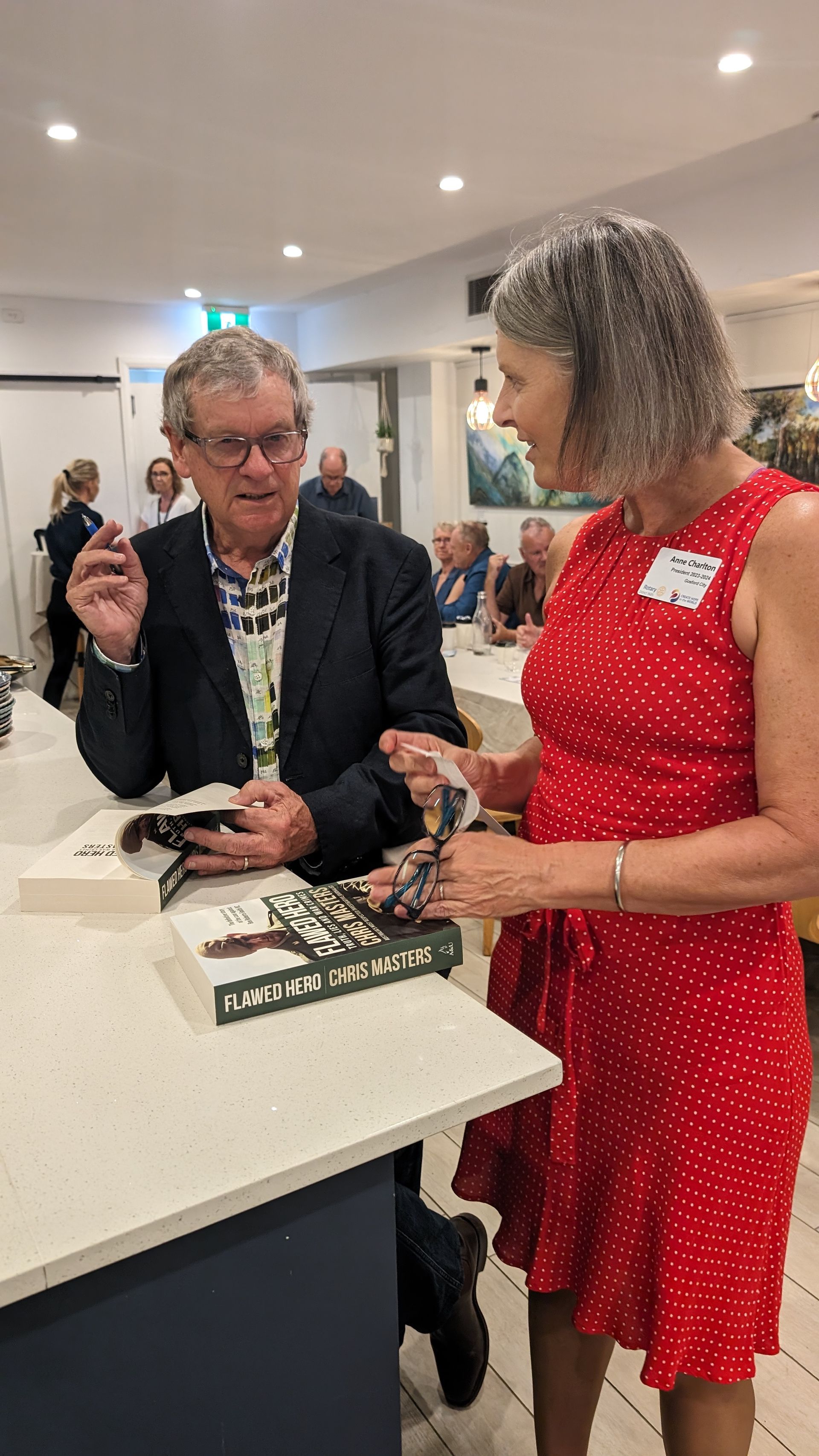 A woman in a red dress is standing next to a man in a suit.