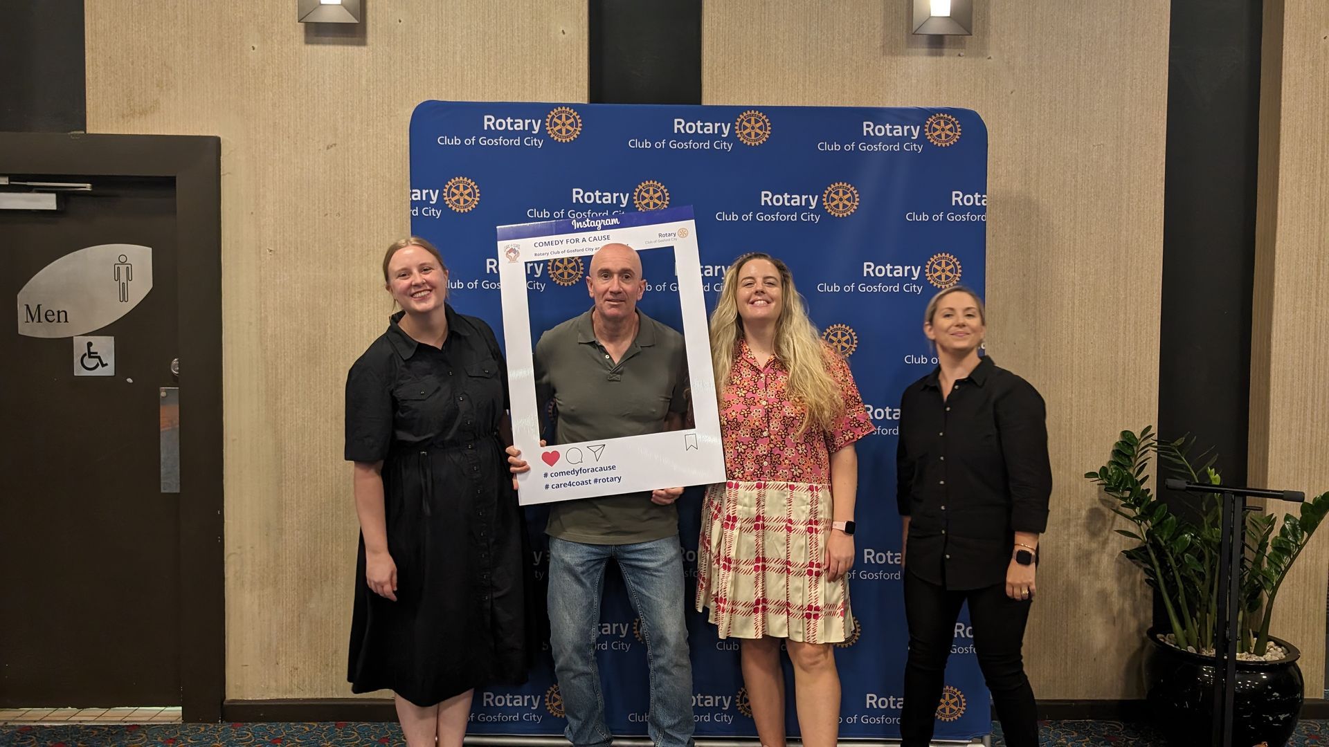 A group of people standing next to each other holding a picture frame.