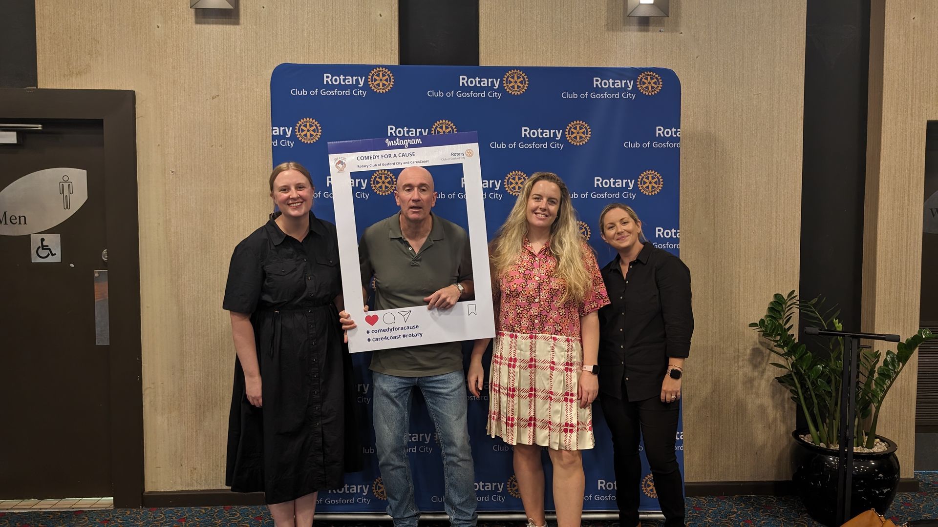 A group of people standing next to each other holding a picture frame.