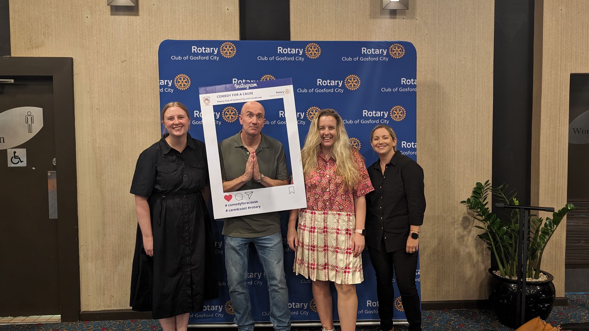 A group of people standing next to each other holding a picture frame.