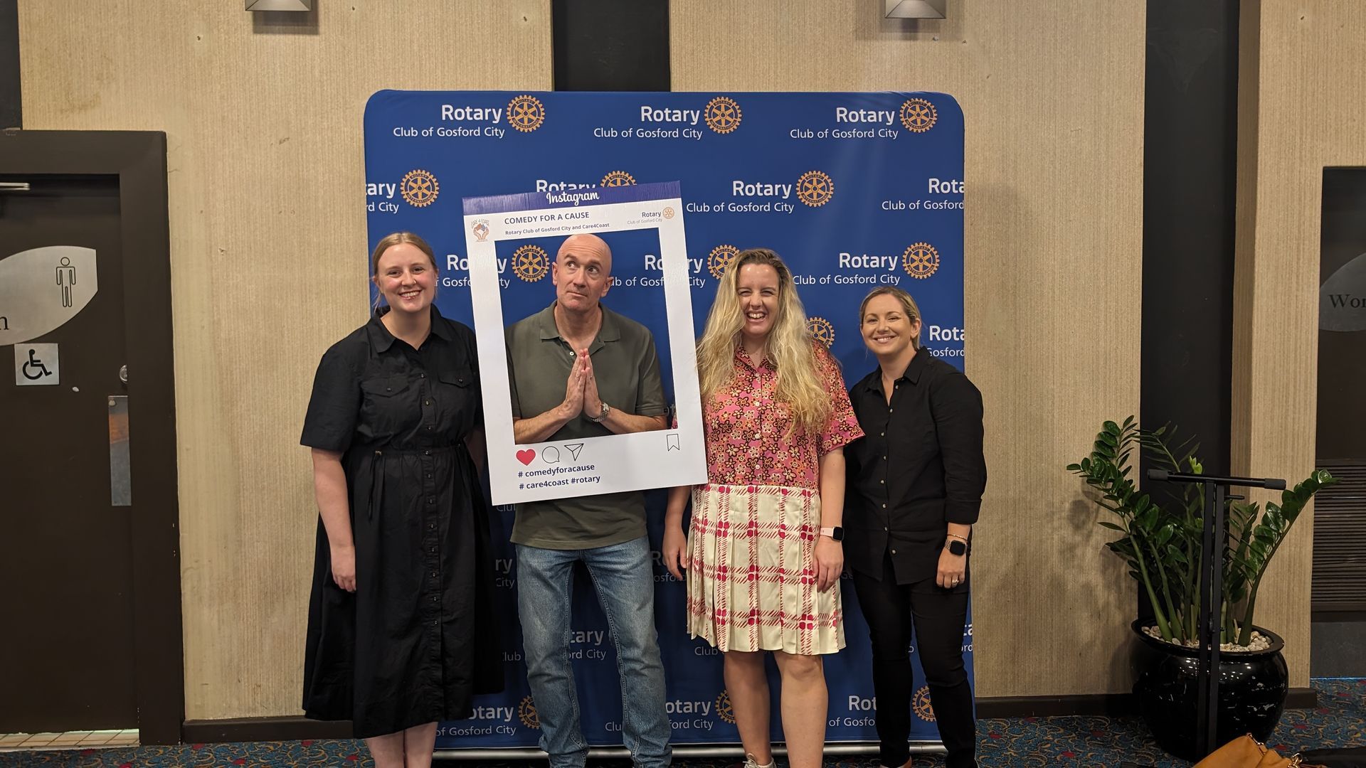 A group of people are posing for a picture with a polaroid frame.