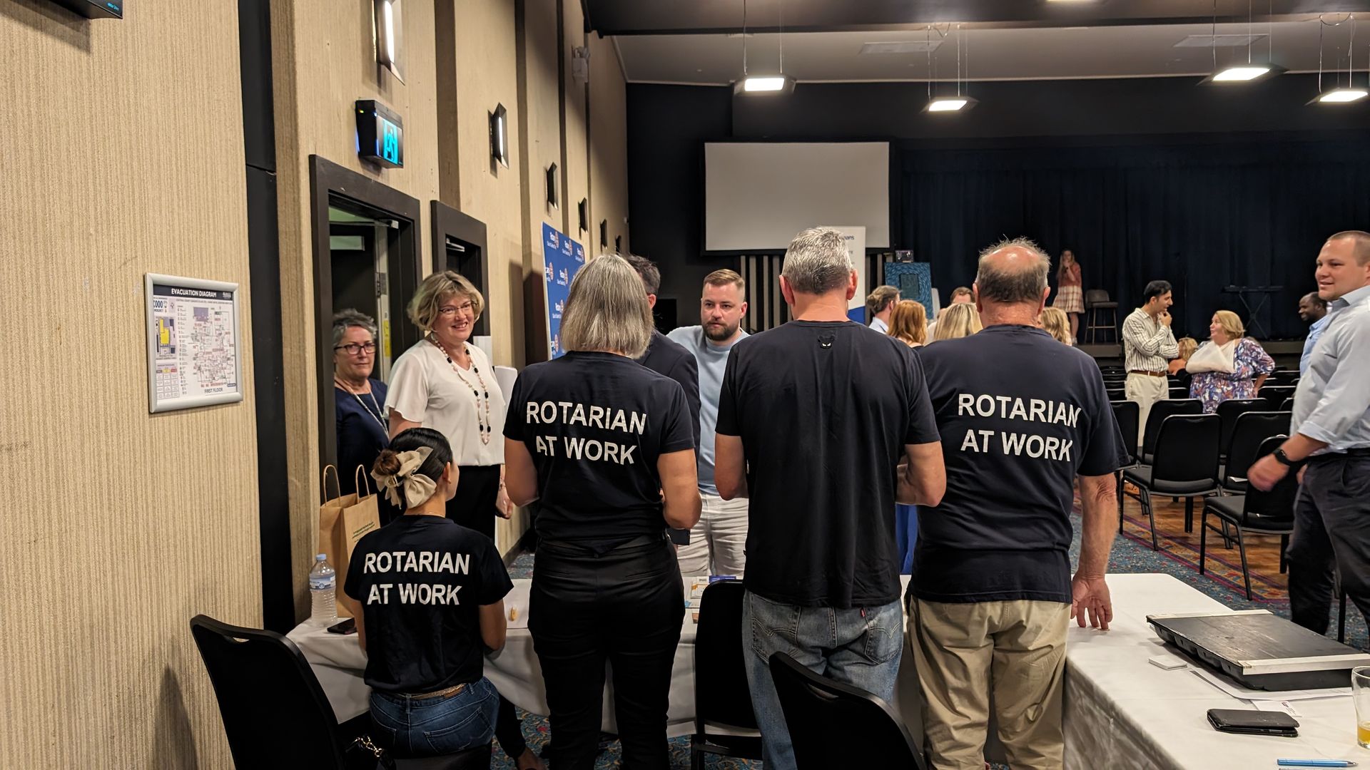 A group of people are standing in a room with their backs to the camera.