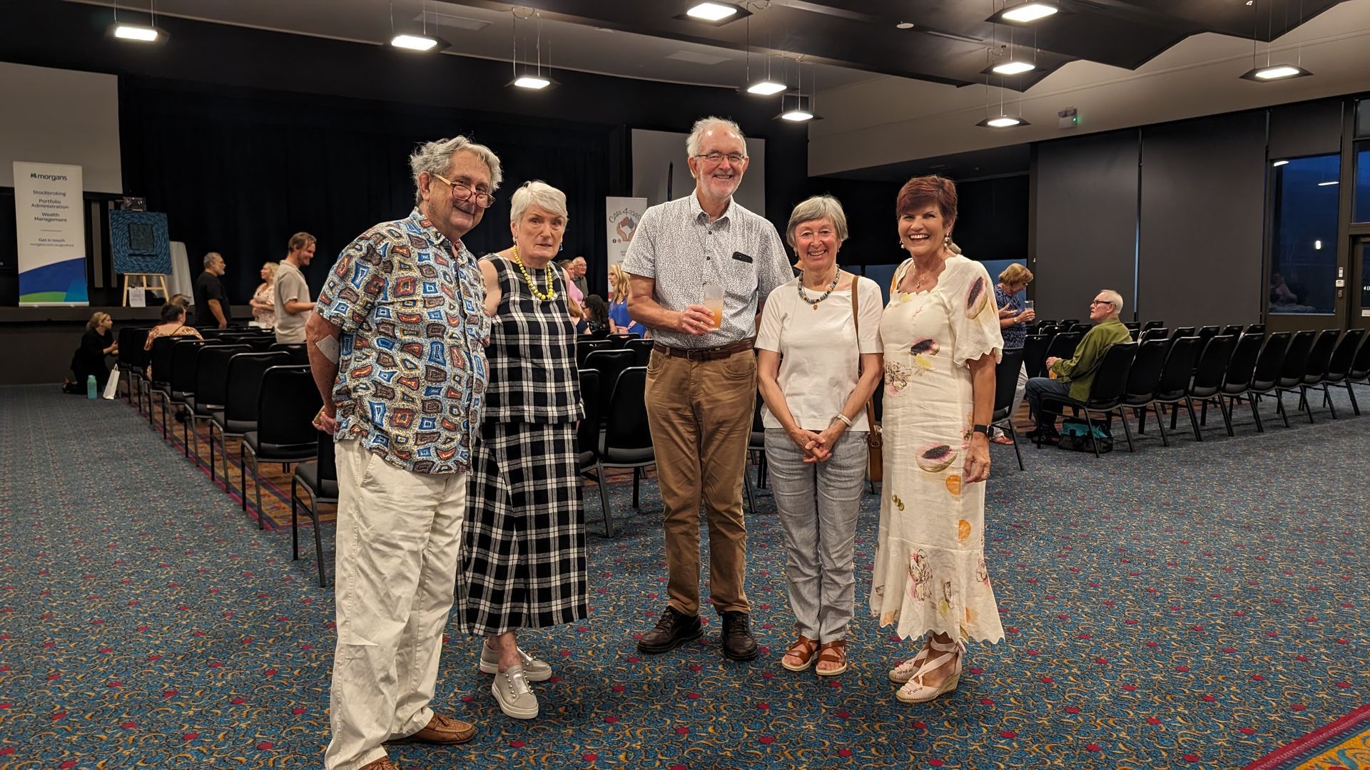 A group of people are posing for a picture in a large room.