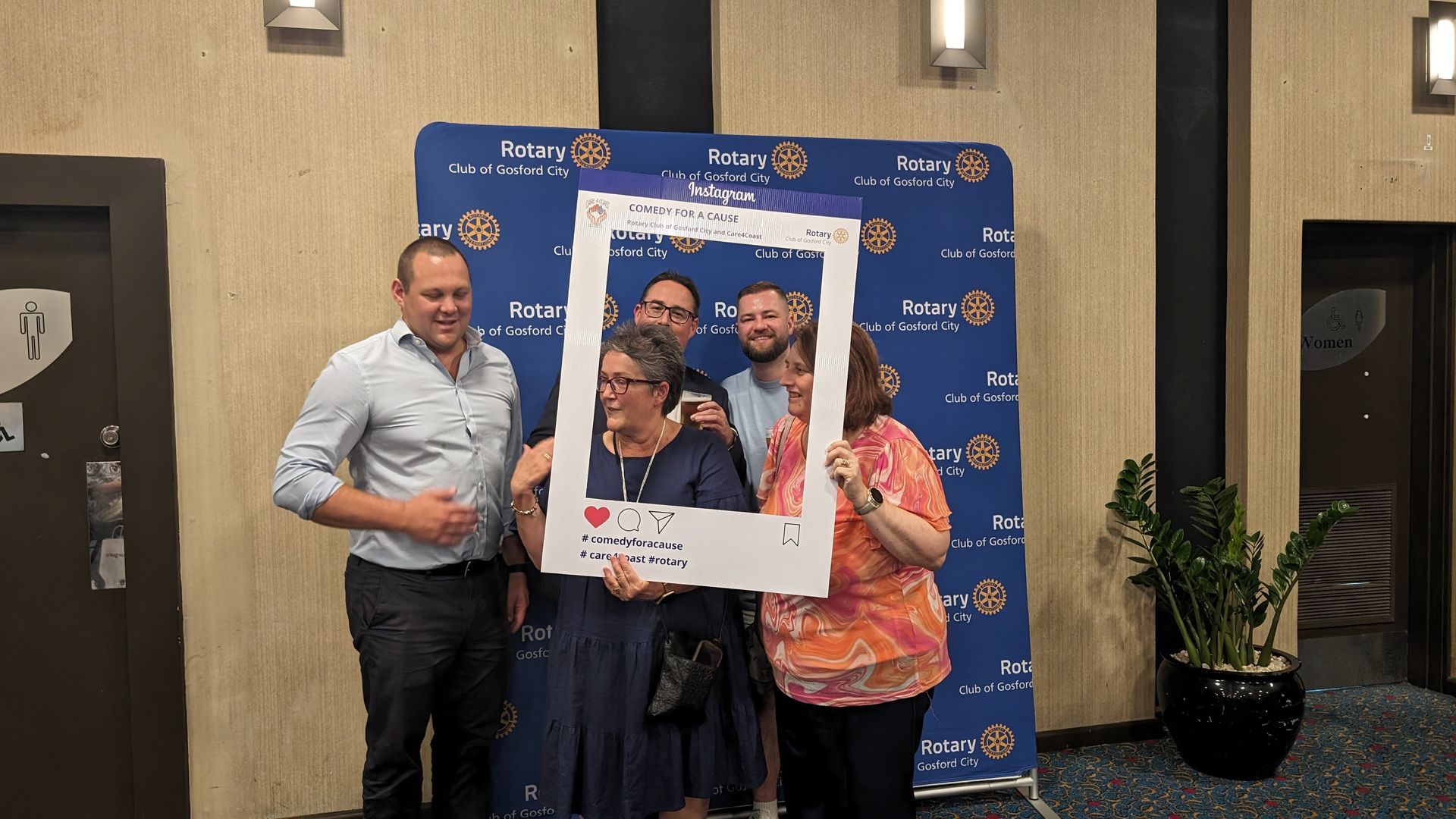 A group of people standing next to each other holding a picture frame.