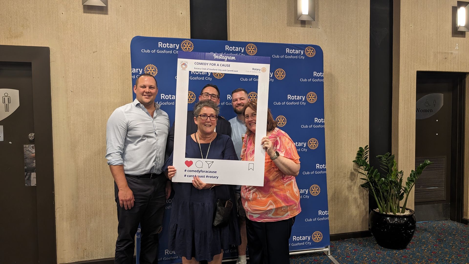 A group of people standing next to each other holding a picture frame.