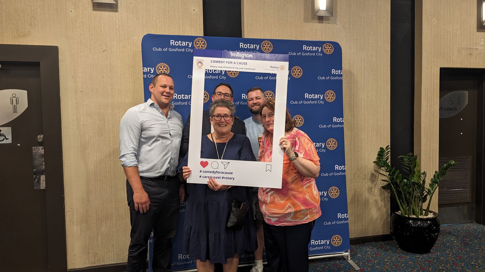 A group of people standing next to each other holding a picture frame.