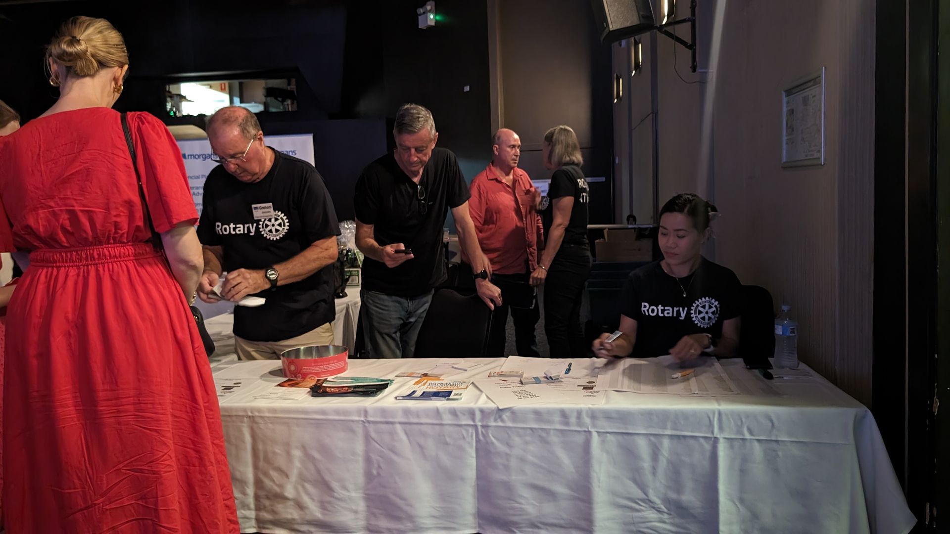 A group of people are standing around a table.