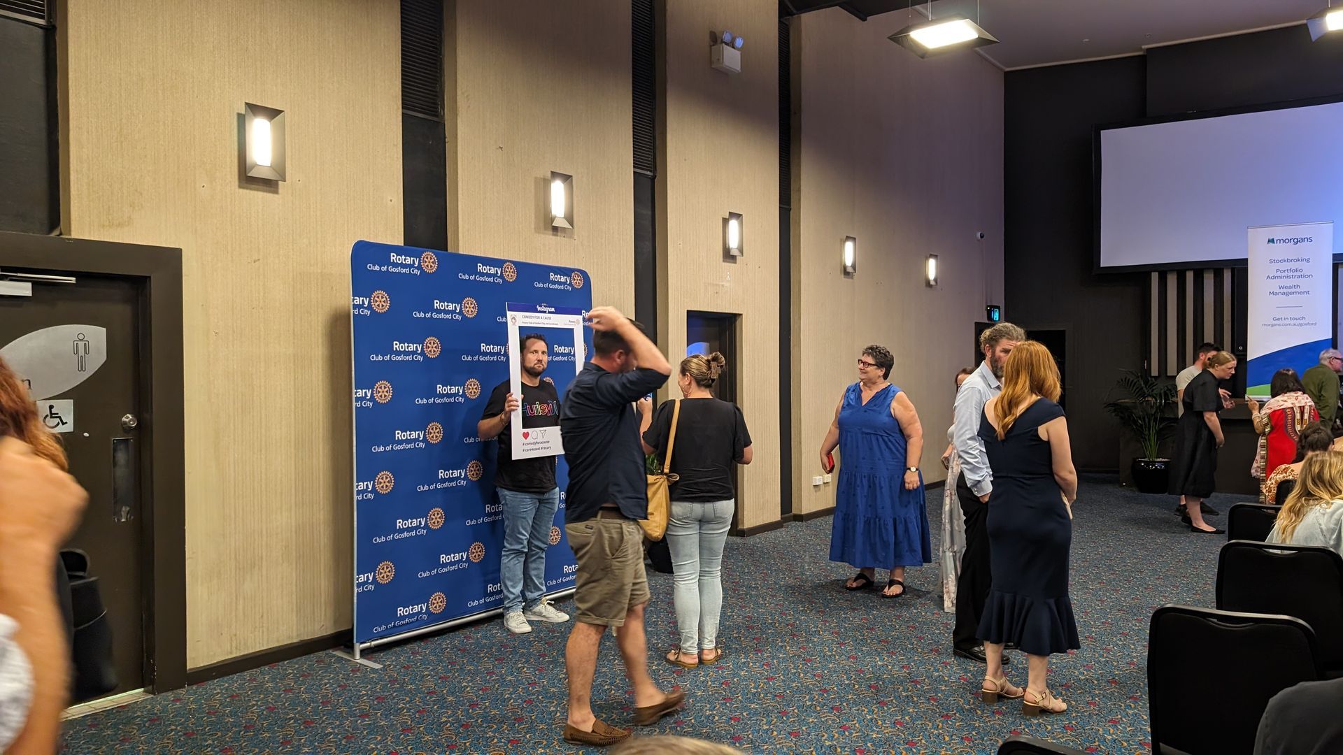 A group of people are standing in a large room.